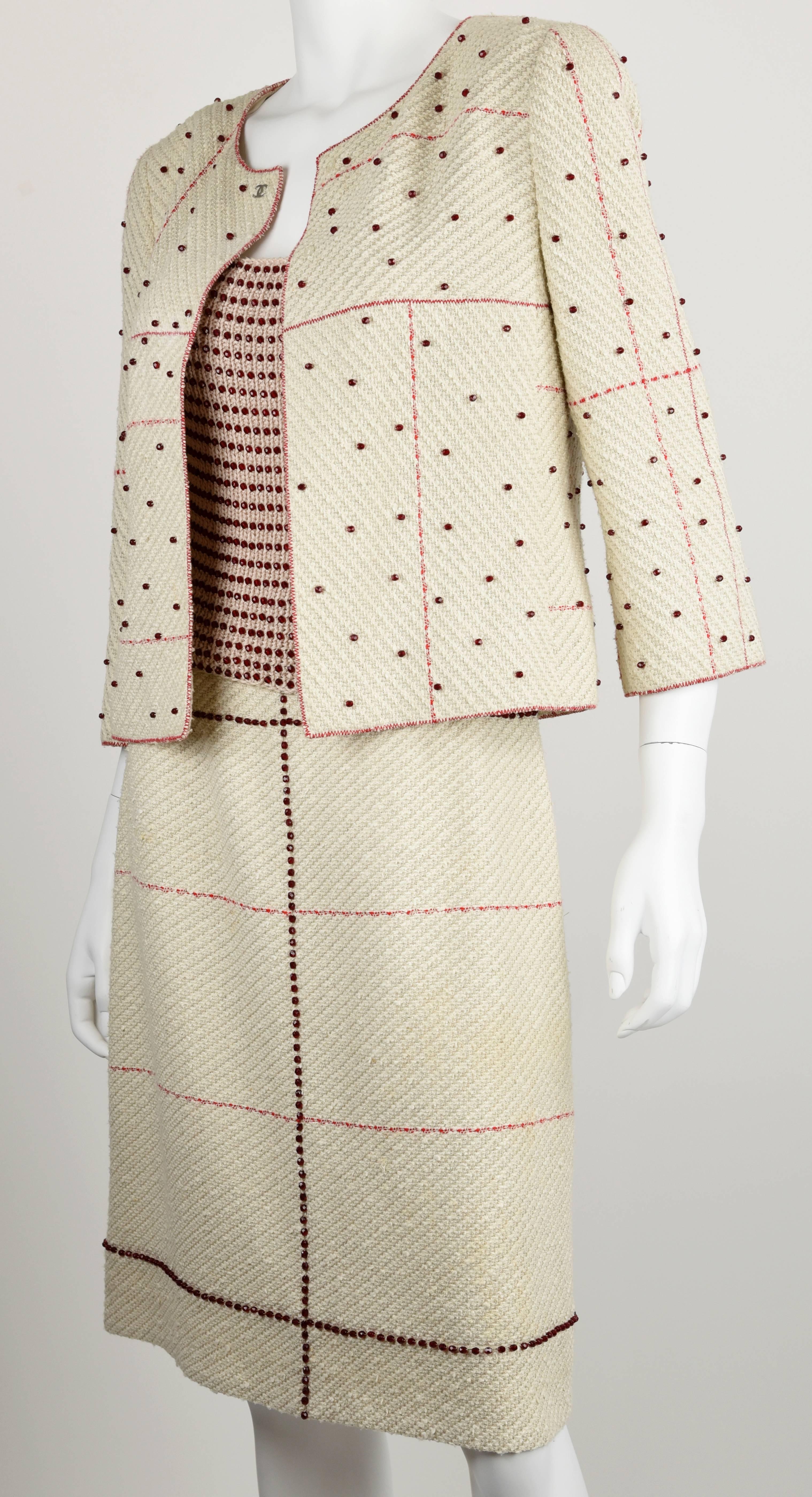 Thousands of red sparkling beads have been hand sewn on the jacket, the top and the skirt. The fabric is linen, cotton, nylon and wool, woven in a dimensional diagonal and Mondrian pattern The top has a surprising solid beading all the way around,