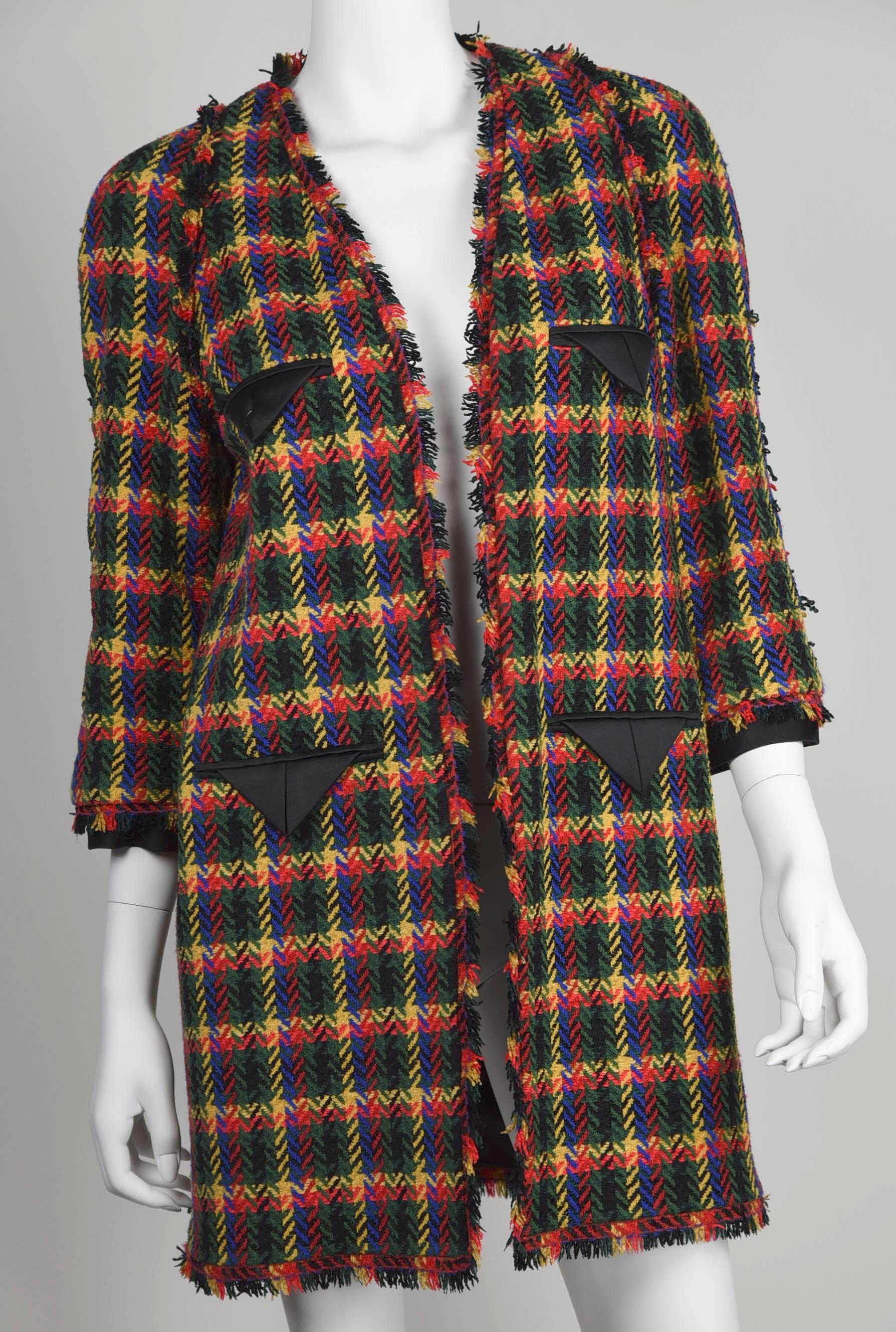 A bright yellow, green, red and black plaid three-quarter coat to perk up black Chanel dresses, skirts and pants.  Fabric is 47% acrylic, 42 % wool and 11% nylon and lining/trim is 100% silk black satin.  Measurements are:  Height 33". Bust
