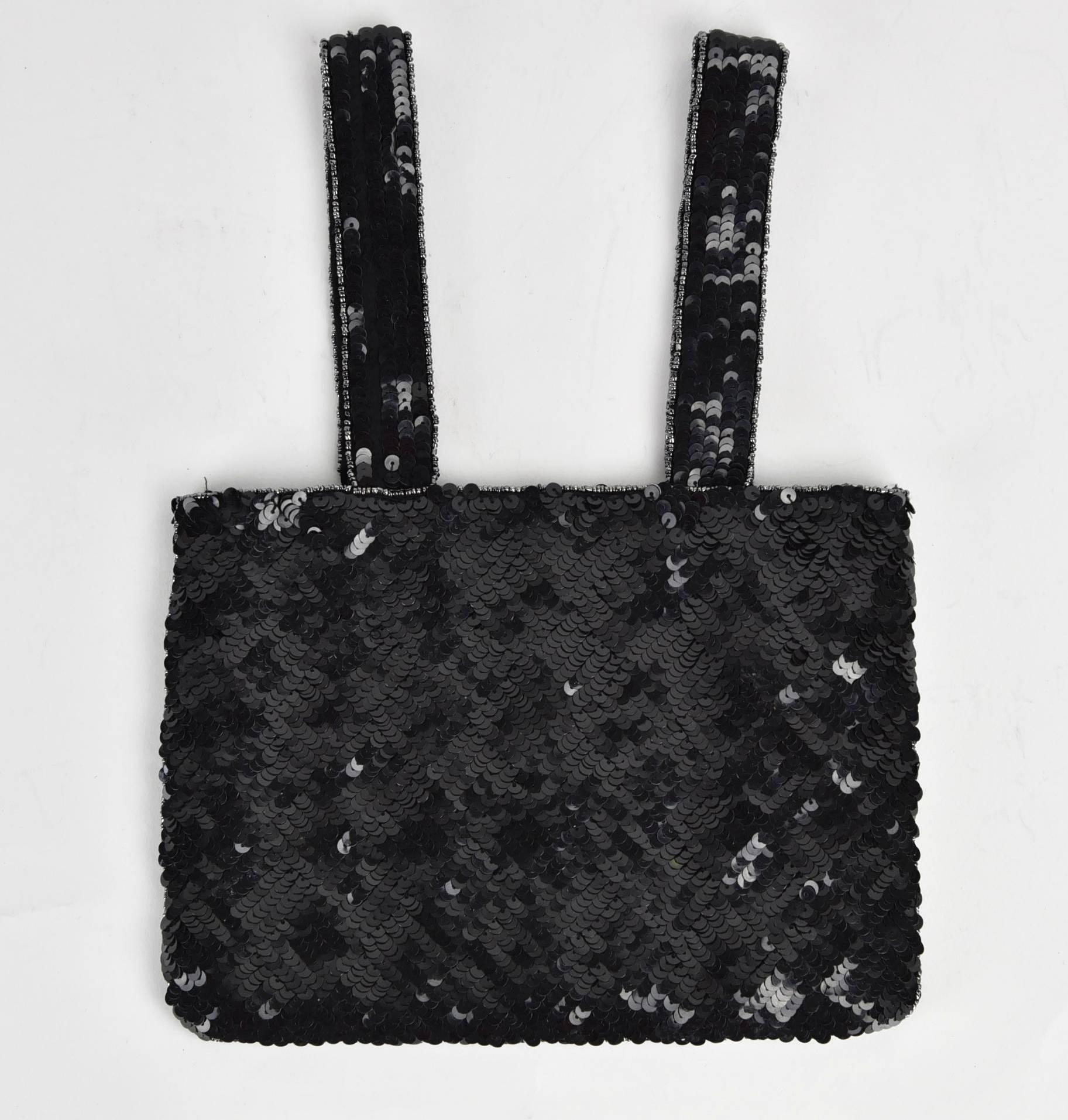 This is a Chanel evening arm bag that is a dressy version of the classic Chanel handbag, but executed in closely sewn black sequins, outlined with silver beads and finished with a rhinestone CC. It measures 9" Wide, 6.5" Height and with