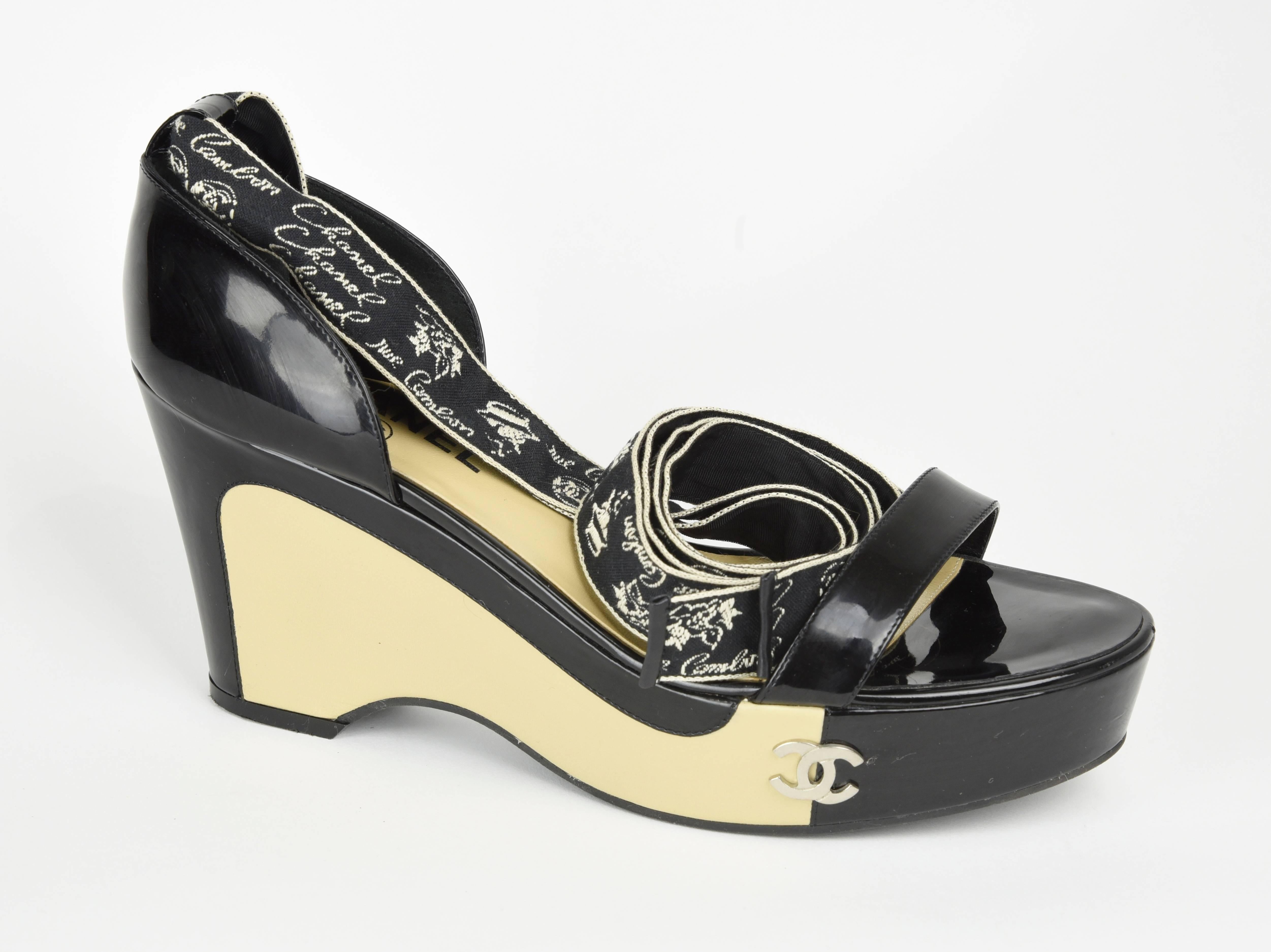 Chanel gorgeous graphic design in black and beige patent leather platform sandals with 56" black and white woven pattern 1" ribbons with woven images of Coco Chanel in a hat and "Rue Cambon", that wrap two times around the ankle.