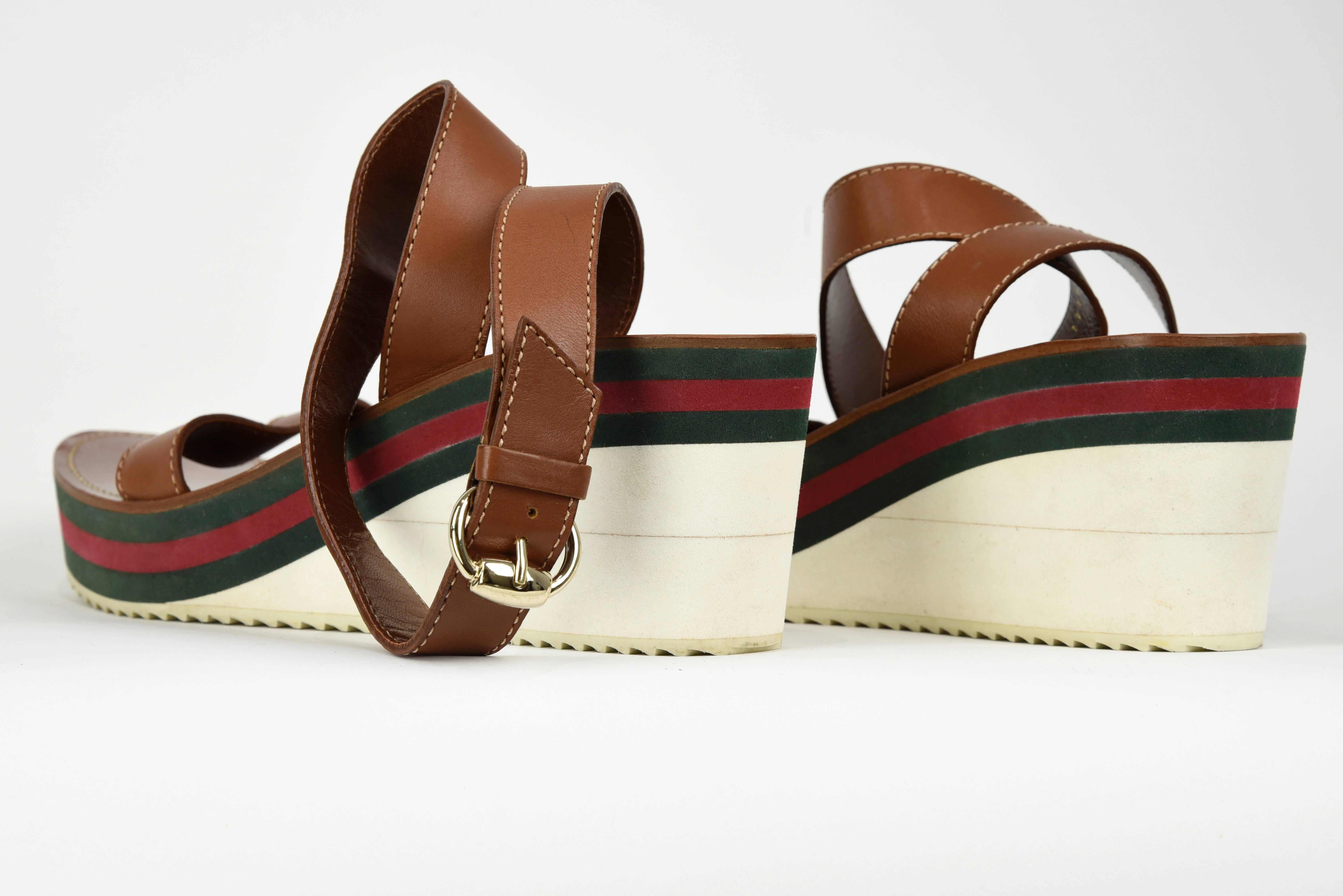 Recognizable bold red and green Gucci stripe underscores this 3 inch heel platform sandal with simple brown leather ankle wrap. They are simple yet elegant casual in design. Soles have very slight signs of use and the tops are