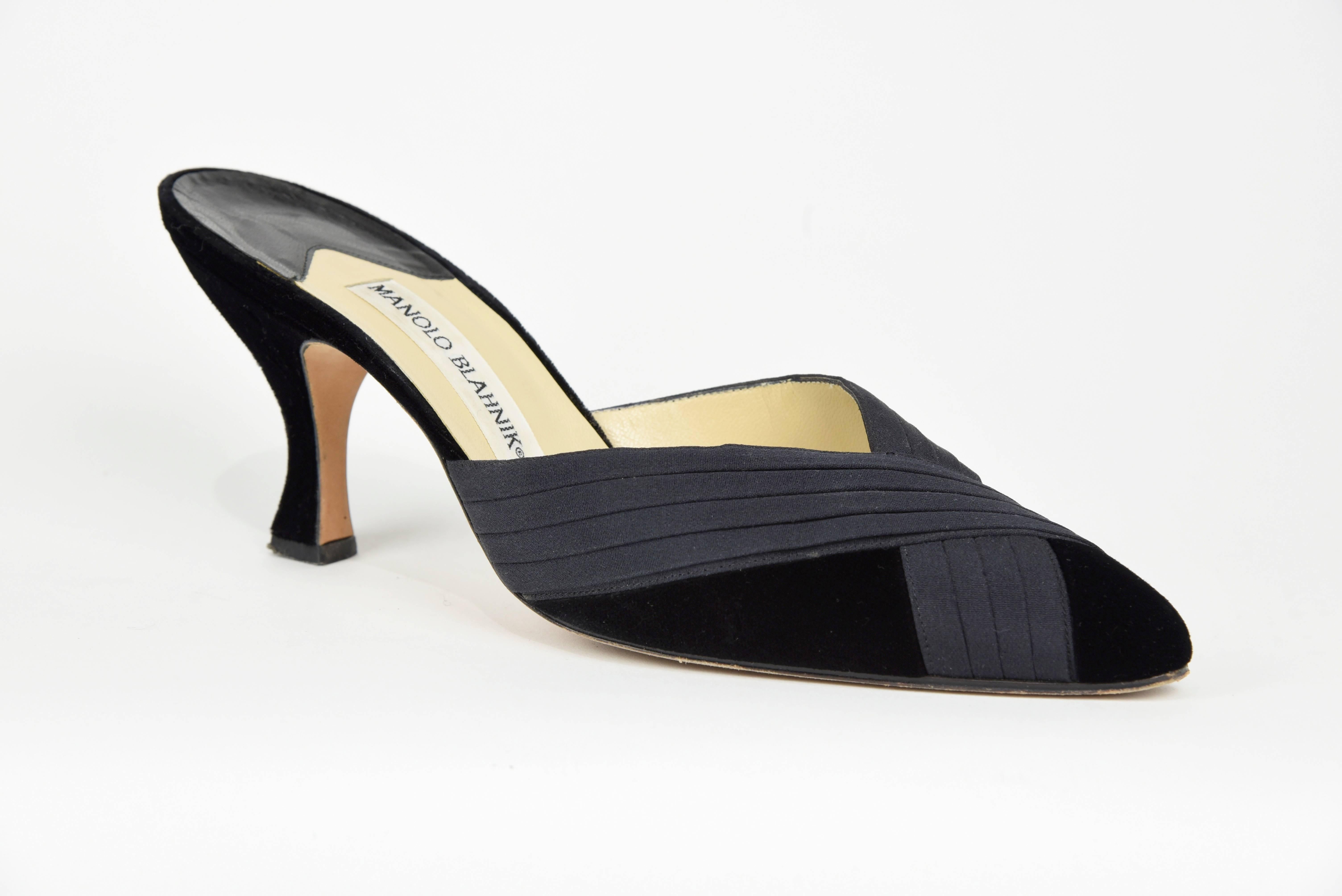 With luscious black velvet and pleated silk, Manolo Blank designed these simple, clean and gorgeous evening backless heels that go with almost any elegant formal gown or pants. These shoes are in excellent condition with slight wear to the sole. 
