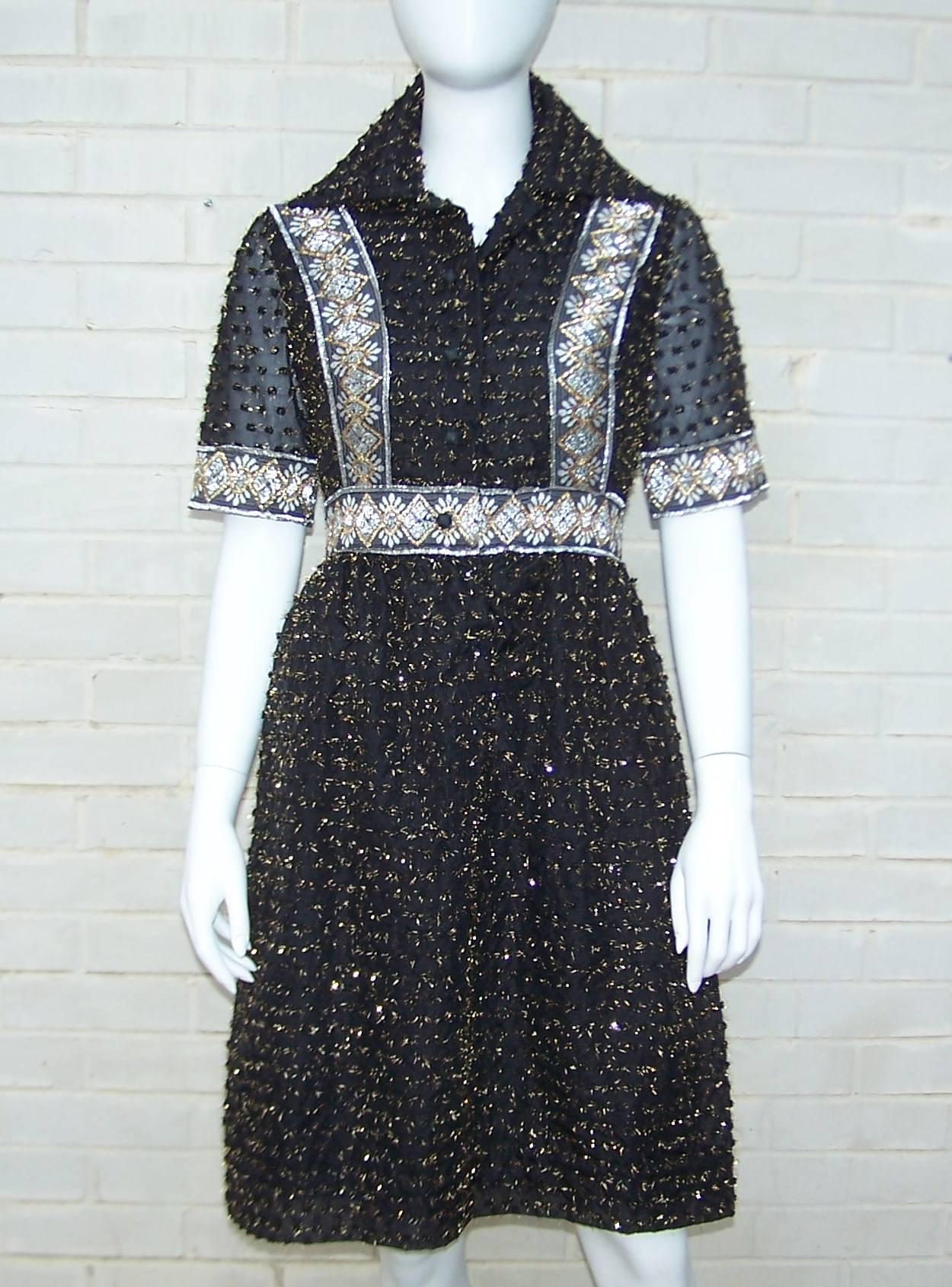 Love the details on this seemingly simple Oscar de la Renta shirt dress.  The paper weight sheer fabric is covered with textural pom poms sprouting gold threads.  The bodice and cuffs are outlined in silver and gold metallic braiding which creates a