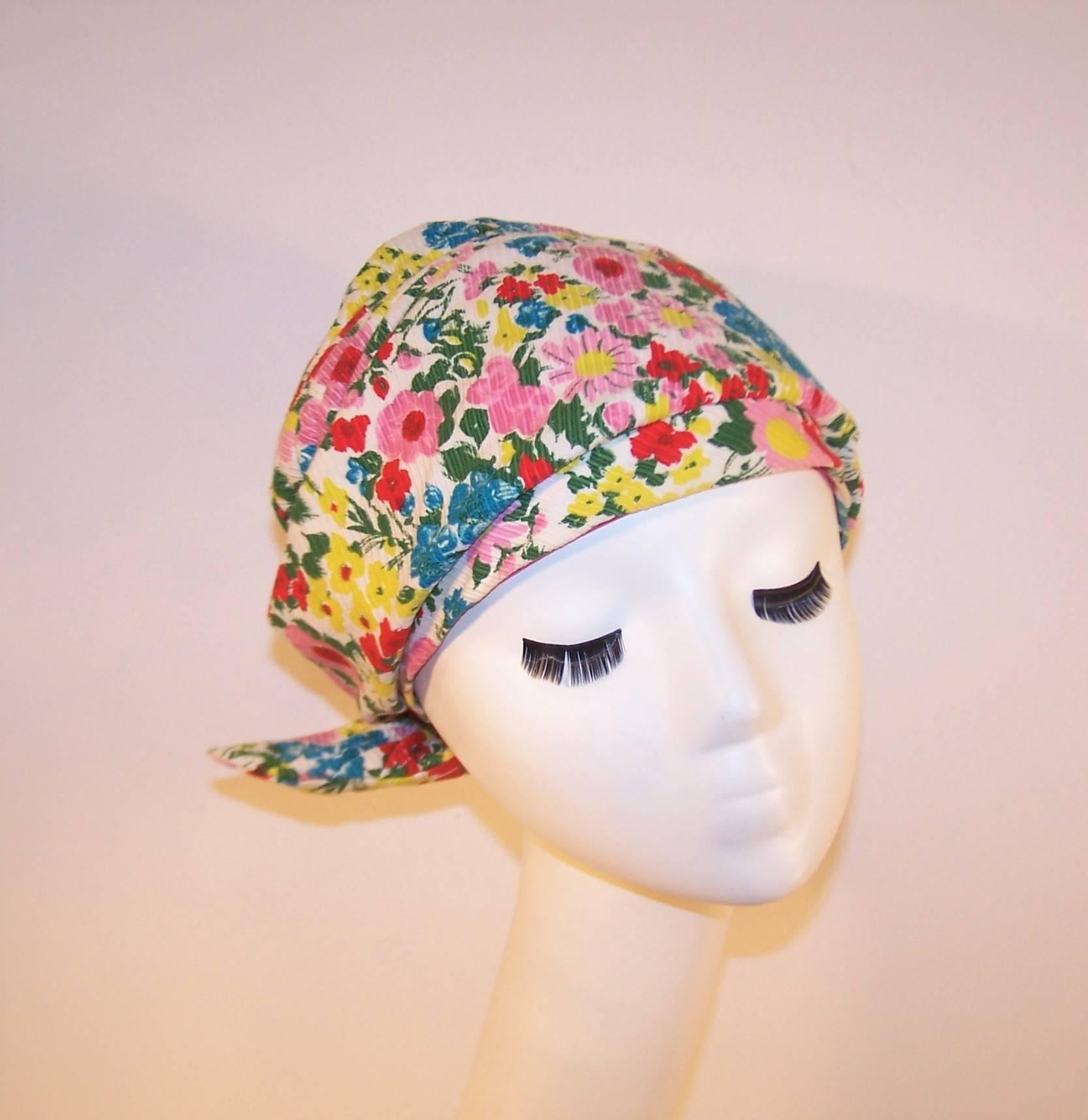 The perfect summertime companion for boat cruises, convertible rides and afternoons at the beach!  This floral turban shaped hat resembles a casual head scarf complete with ruched seams and a crossover tie in the back.  The fabric is a ribbed cotton