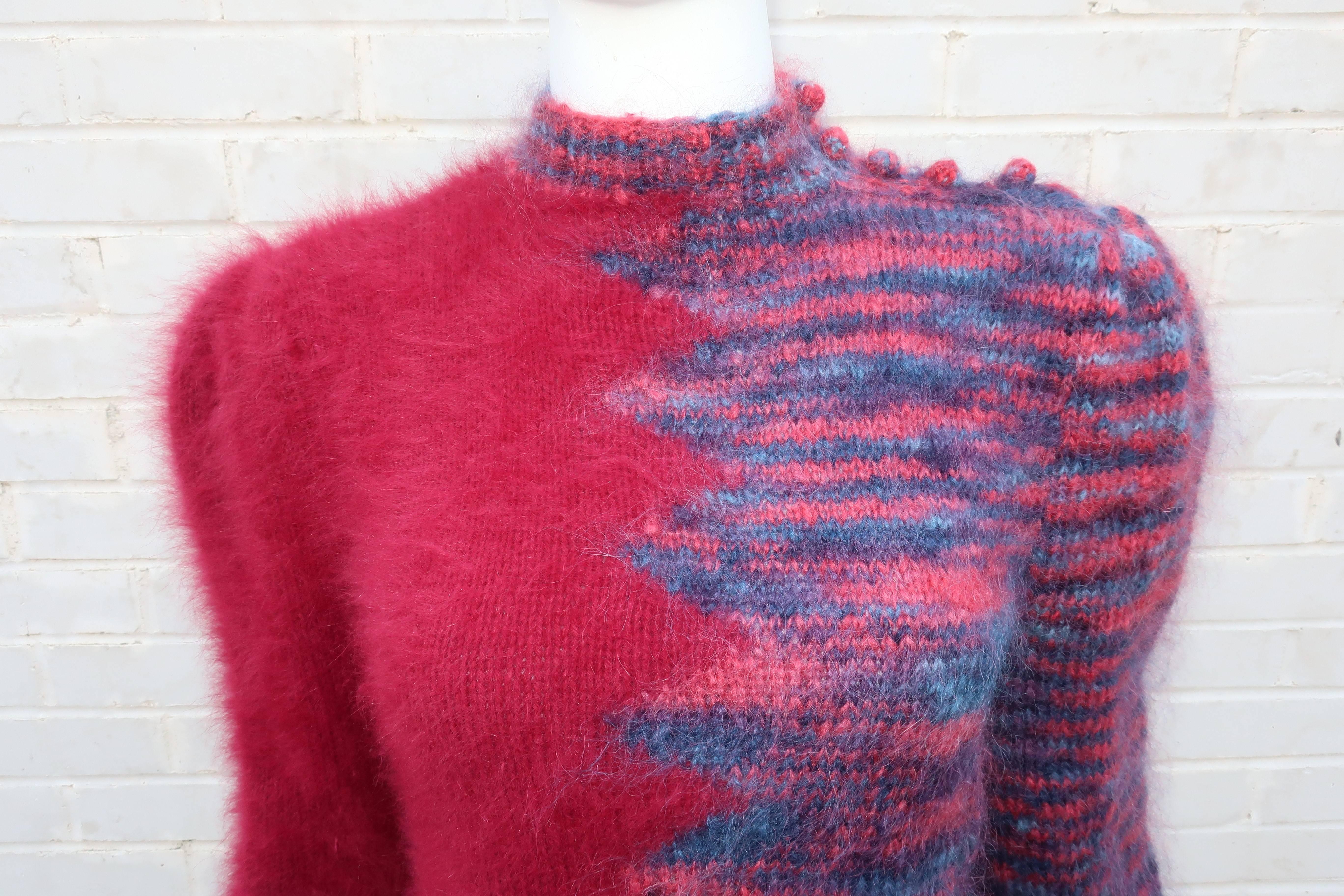 Get prepared to be touched! This 1970’s hand knit angora sweater is irresistible.  The mock turtleneck pullover has buttons on one shoulder and a ribbed waistband with coordinating cuffs.  One side is a lovely cranberry red with hints of dark