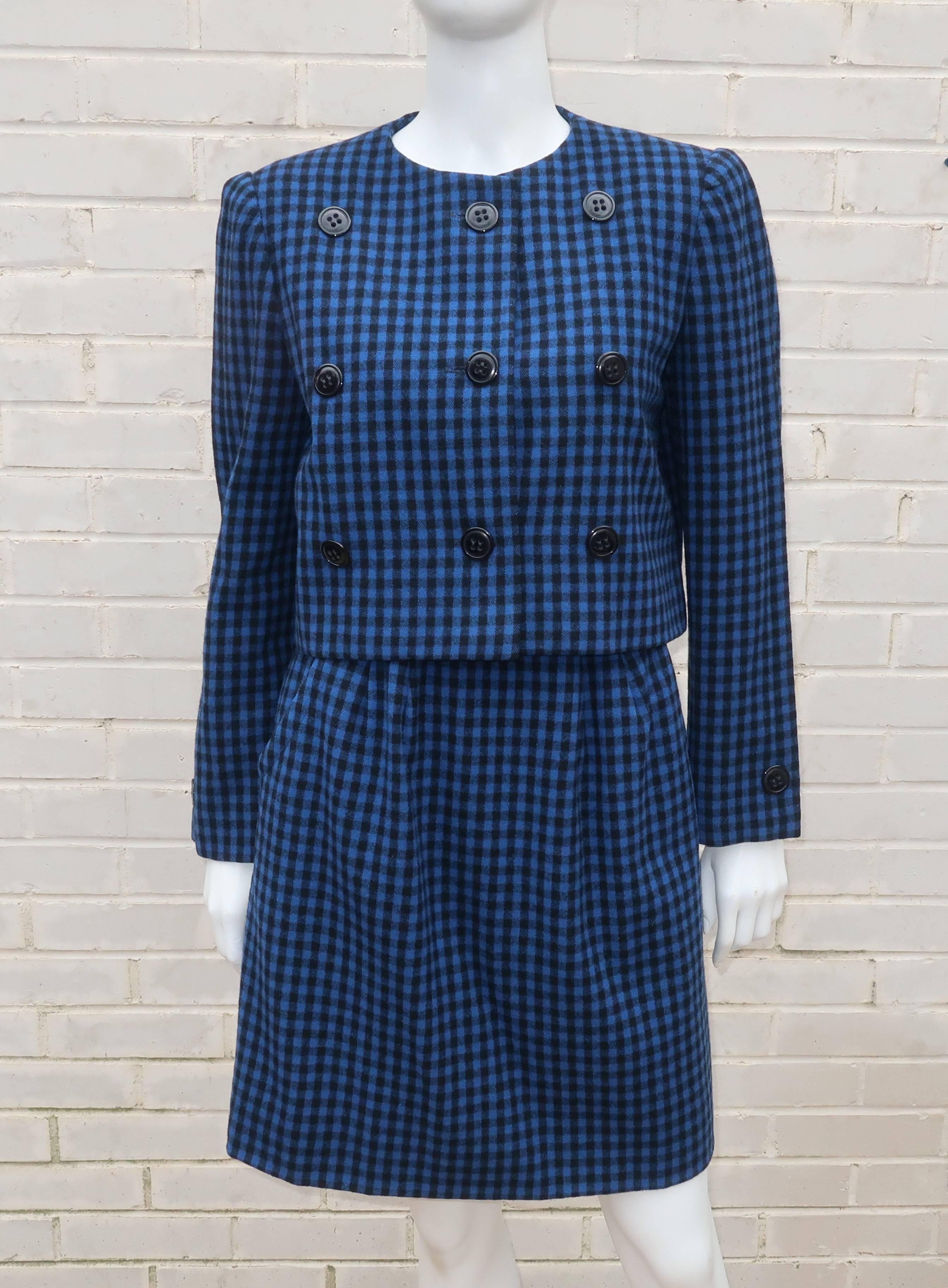 Delightfully demure with a good dose of style and sophistication ... all hallmarks of this C.1970 Mollie Parnis two piece suit.  Both the jacket and skirt are fabricated with a brilliant blue and black gingham wool fabric.  The boxy cropped jacket