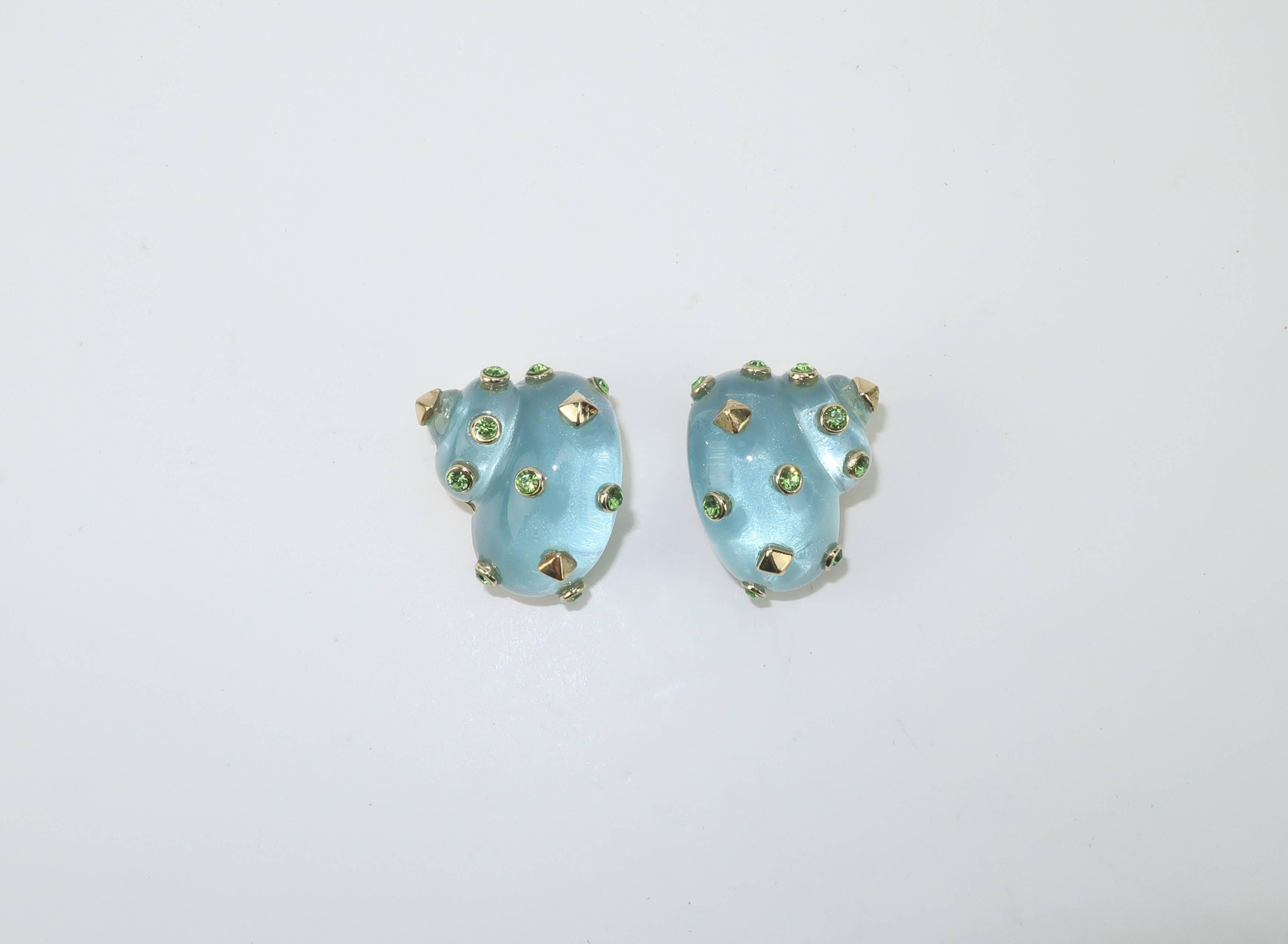 Worthy of a goddess from the seas!  These gorgeous Replica earrings are a sea mist nautilus shape embellished with gold studs and peridot style green crystals.  The translucent resin body of the earrings creates a glow that is sure to draw