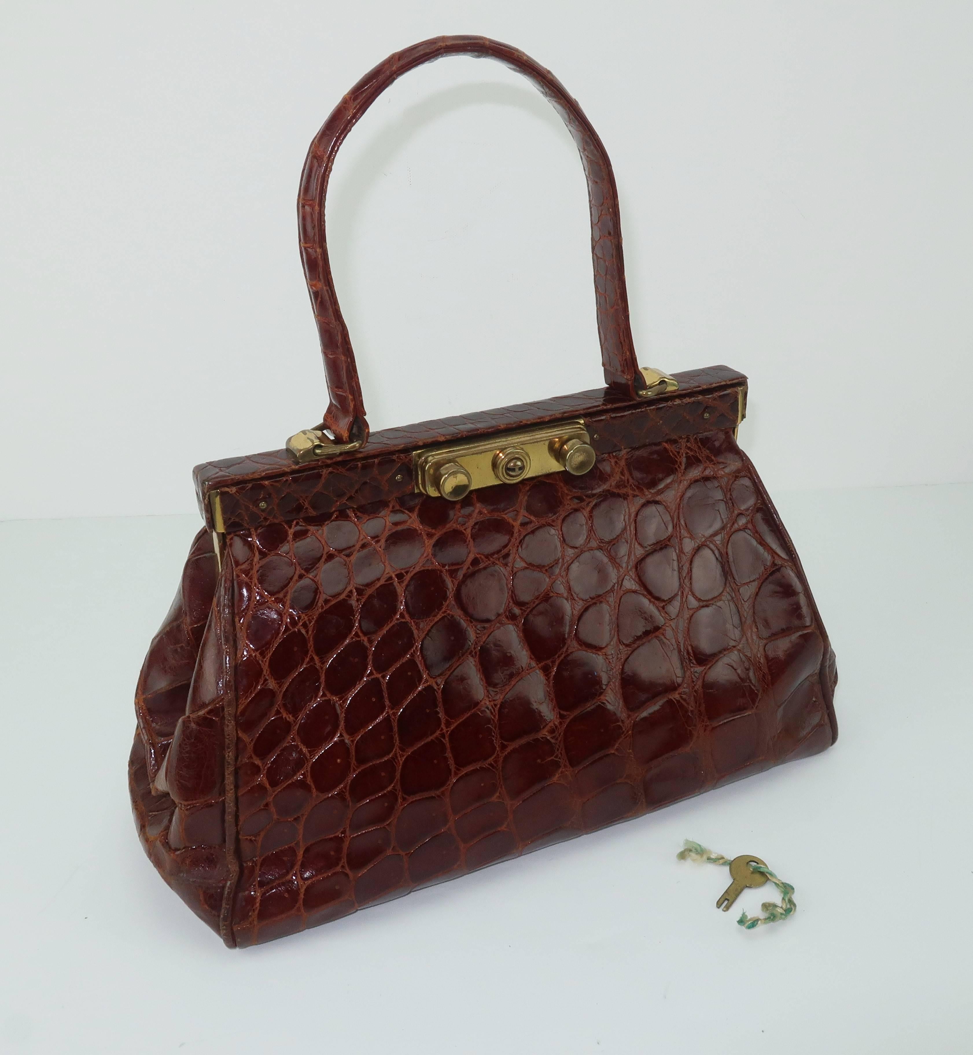 Fashion follows function with this classic 1950's bordeaux alligator top handle 'Doctor's bag' style handbag.  Medical bags were fabricated to provide the user storage with a durable design that locks safely for security ... all attributes of this