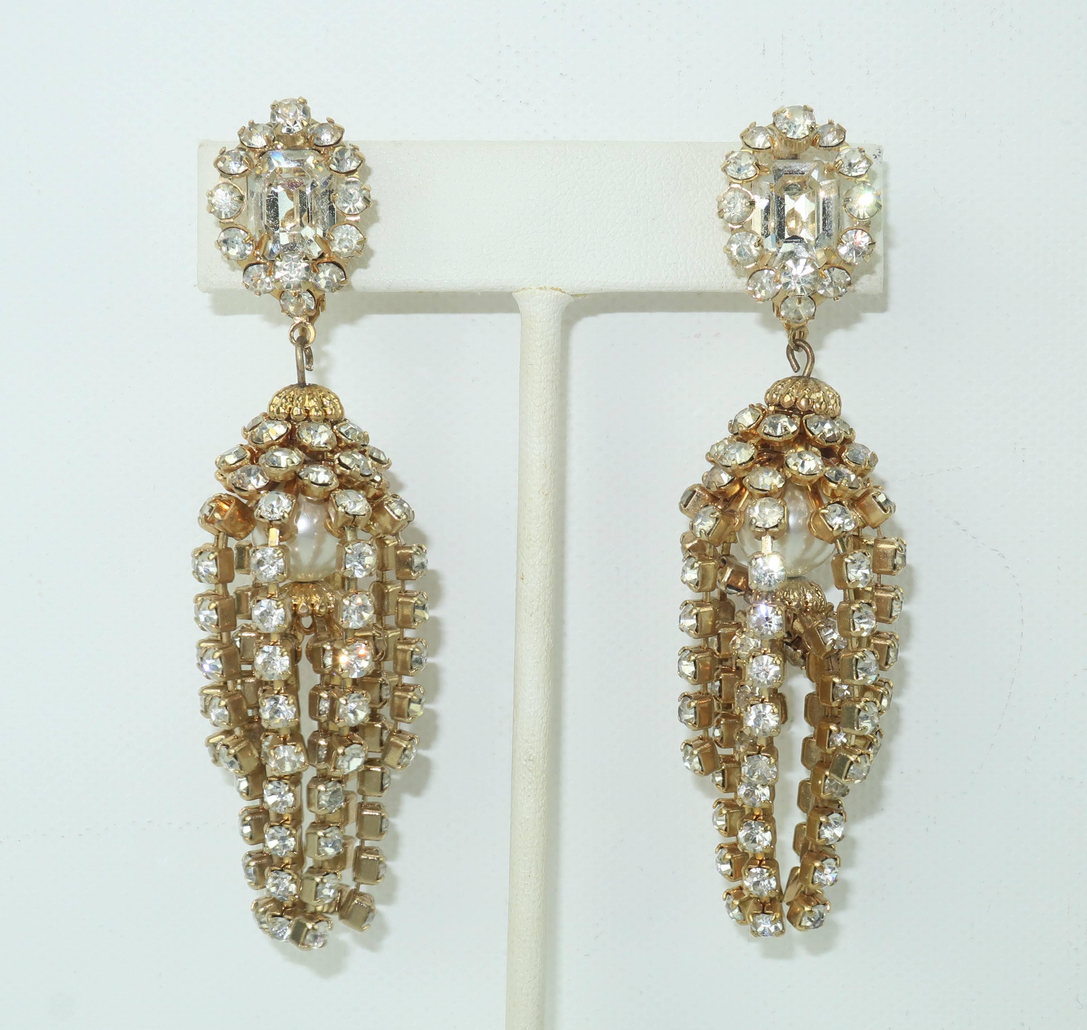Chandelier earrings can transform your look ... especially when they actually look like miniature chandeliers!  These ultra glamorous clip on earrings are created by two tiers of rhinestone chains dangling from a squared rhinestone base.  The center