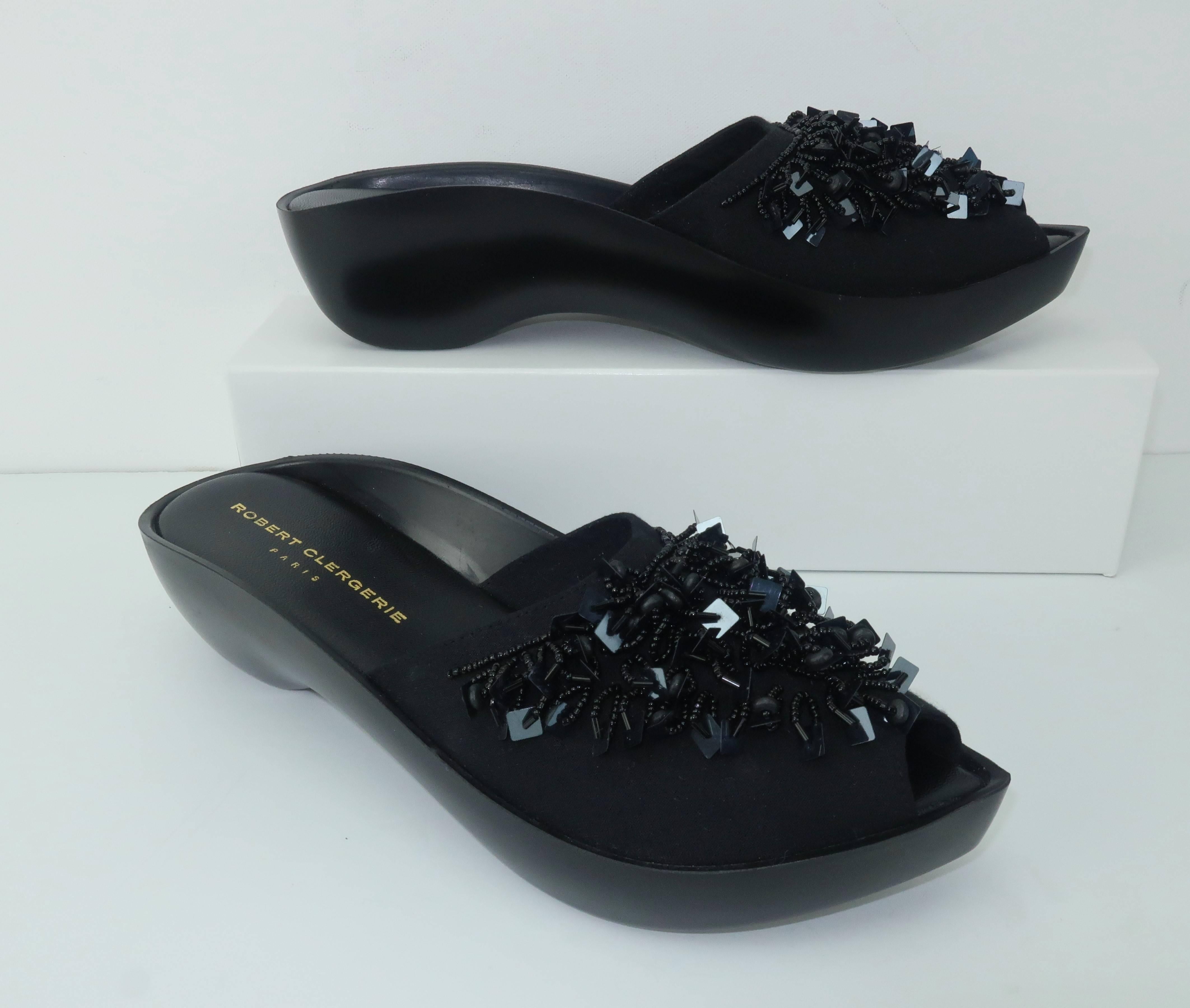 Robert Clergerie has created a comfortable slide sandal in black canvas with peep-toe construction embellished with looped beads and square sequins.  The curved rubber sole and pointed toe are typical of Clergerie designs and are reminiscent of