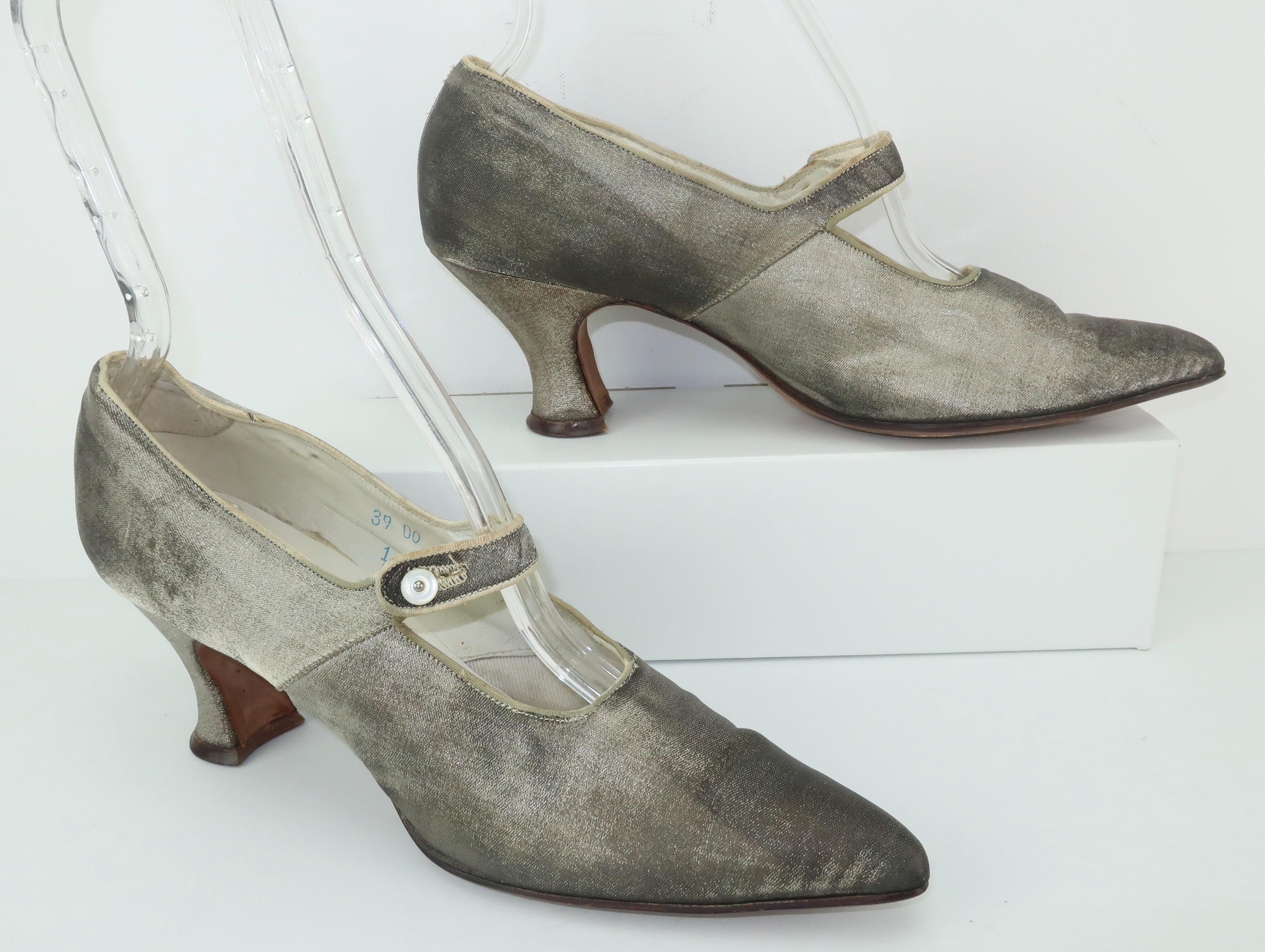 Don your favorite flapper dress and do the Charleston all night long in these silver metallic 1920's shoes.  The pointy toed Mary Jane style silhouette features Louis heels, mother-of-pearl buttons at the strap and leather lined interior.  The