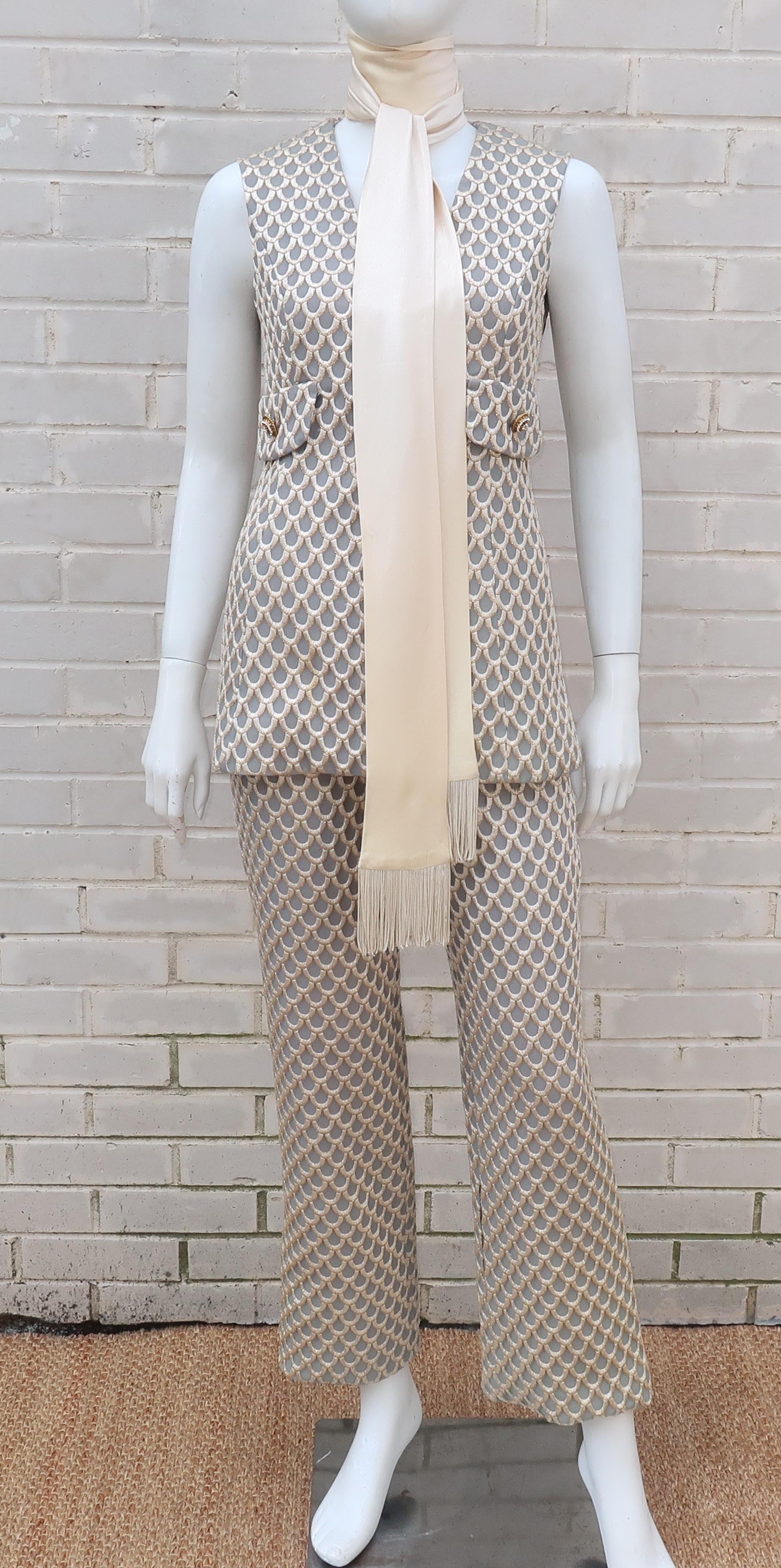Conjure up a little mod magic with this 1960’s Saks Fifth Avenue three piece pant suit consisting of a maxi vest, flared pants and charmeuse fringed scarf.  The vest and pants are designed with a brocade style fabric in a neutral taupe gray shade