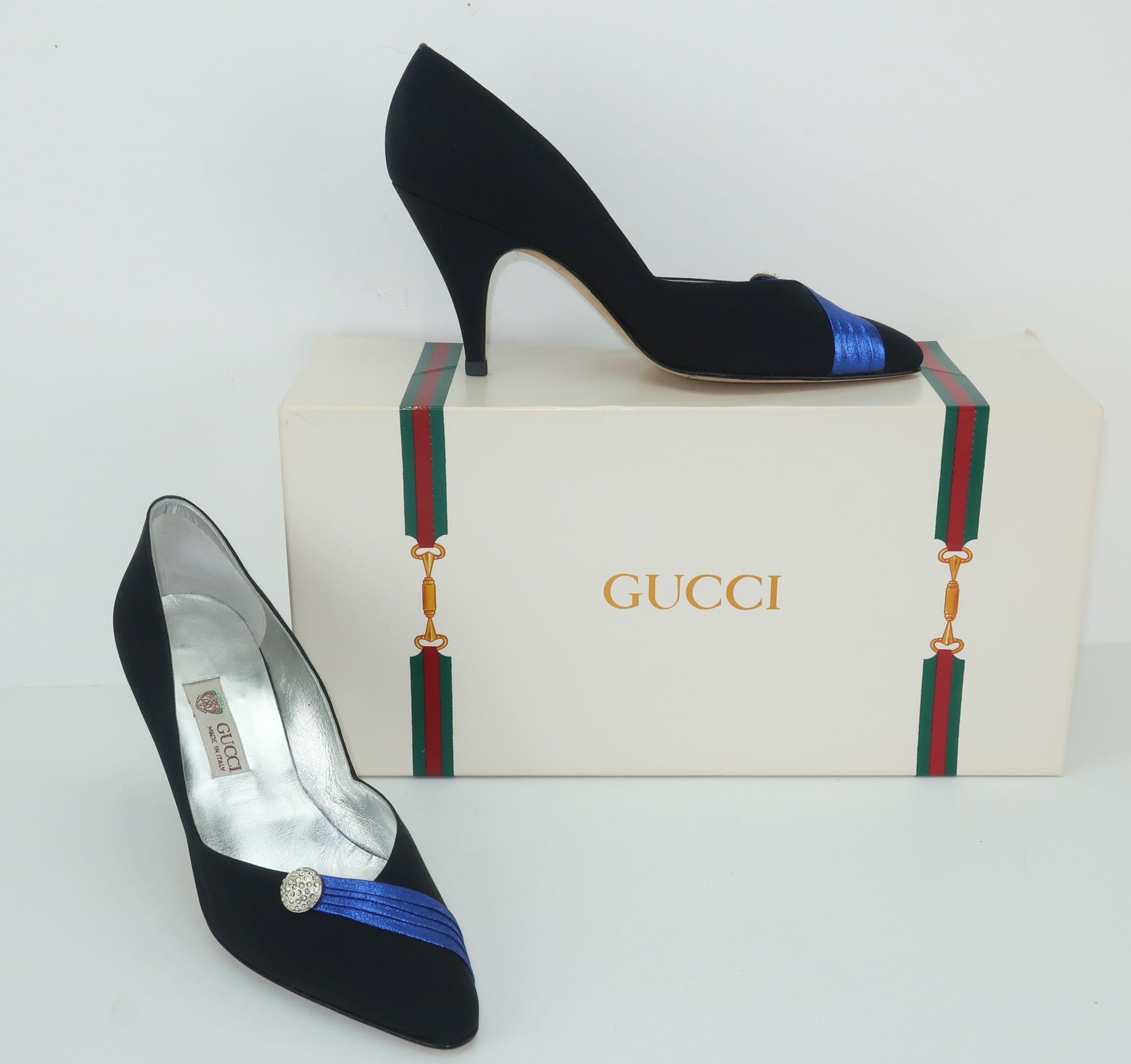 These Gucci evening pumps reign supreme with a royal style sash in a brilliant metallic blue leather adorning the vamps along with a rhinestone encrusted silver metal embellishment.  The 3.5