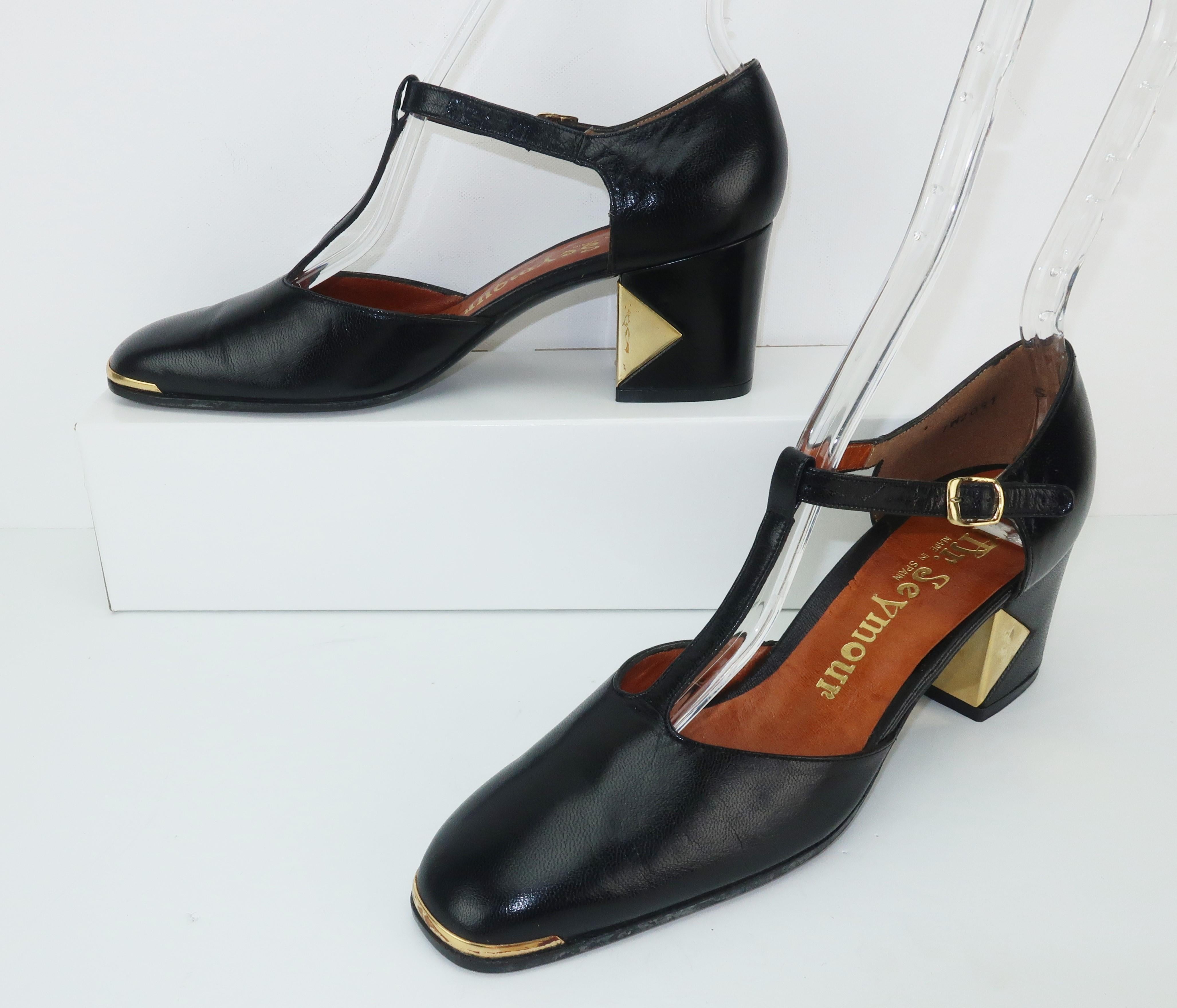 The gold metal details on these 1970's black leather Mr. Seymour shoes really updates the look of a classic t-strap and provides a chic mod aesthetic to the design.  Mr. Seymour was founded by Seymour Weitzman, Stuart Weitzman's father, in the