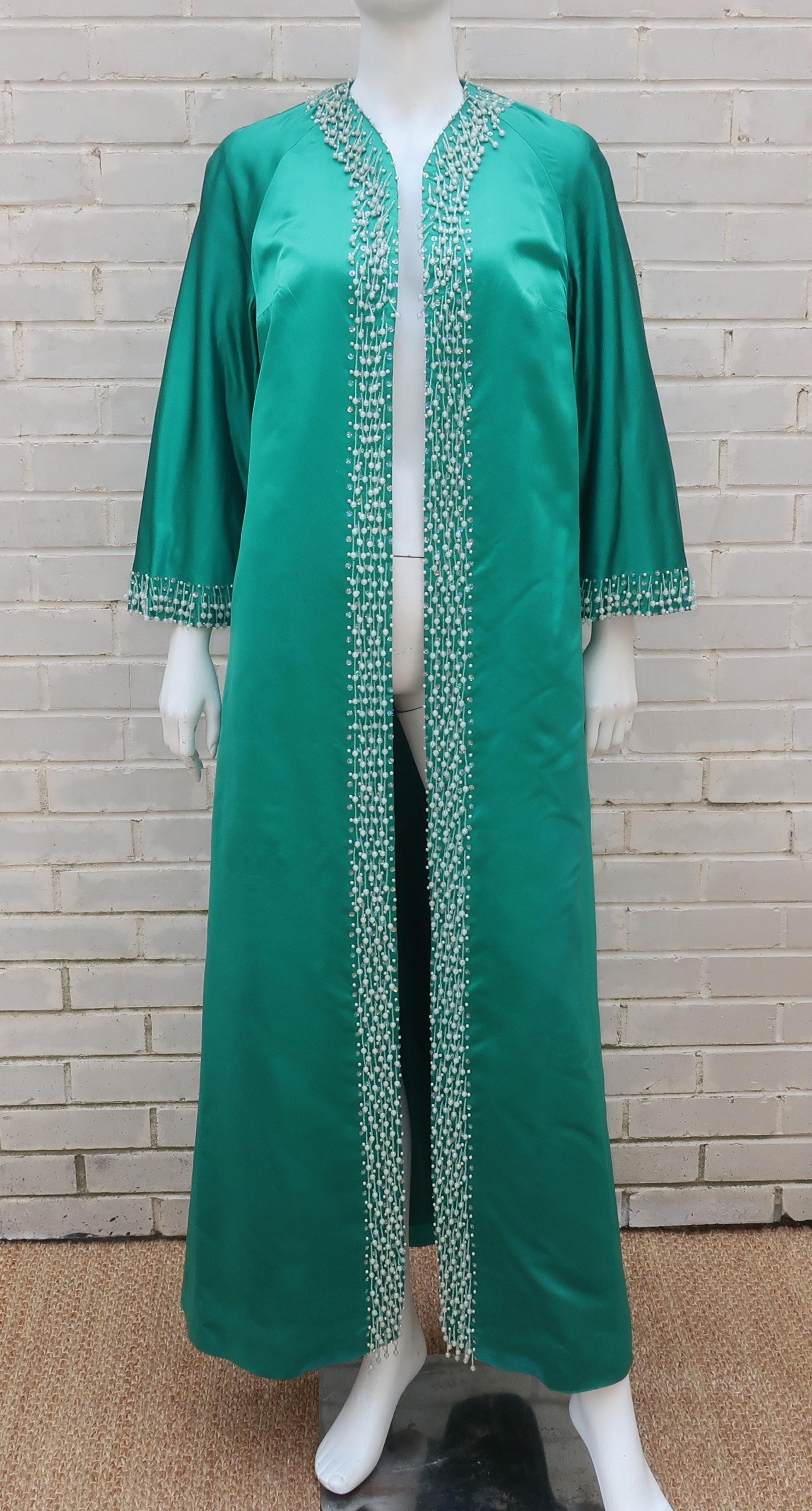 Exotic elegance exudes from this C.1960 jade green satin coat which can be worn as a glamorous hostess robe or as a topper for an evening ensemble.  The silk and rayon blend is fully lined and bears a bluish hint to the rich green shade offset by