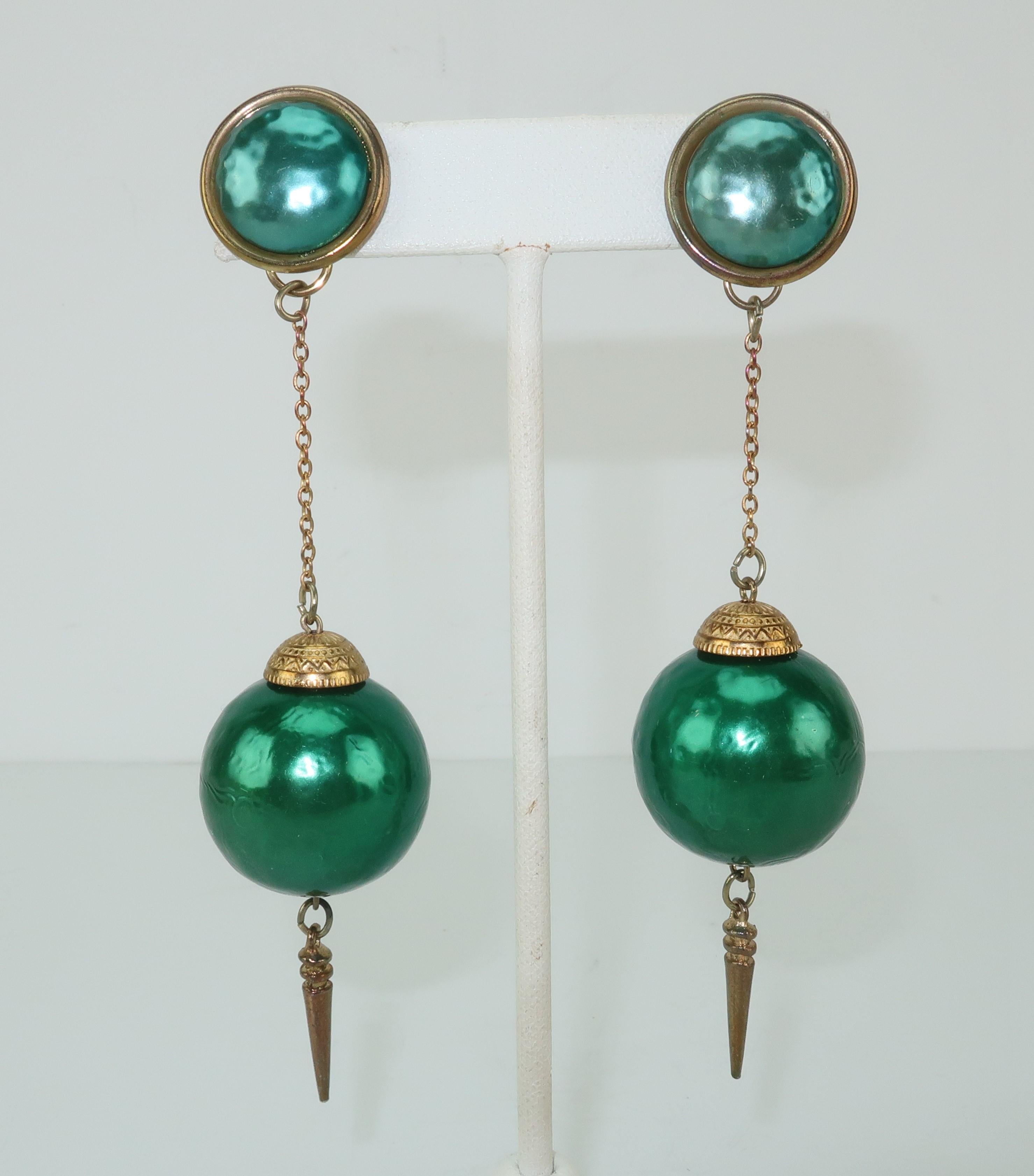 C.1970 pierced post dangle earrings consisting of textured teal green orbs embellished with gold tone metal exotically engraved caps and accented with suspended dagger shaped cones.  The earring bases are also a textured teal green with a subtly