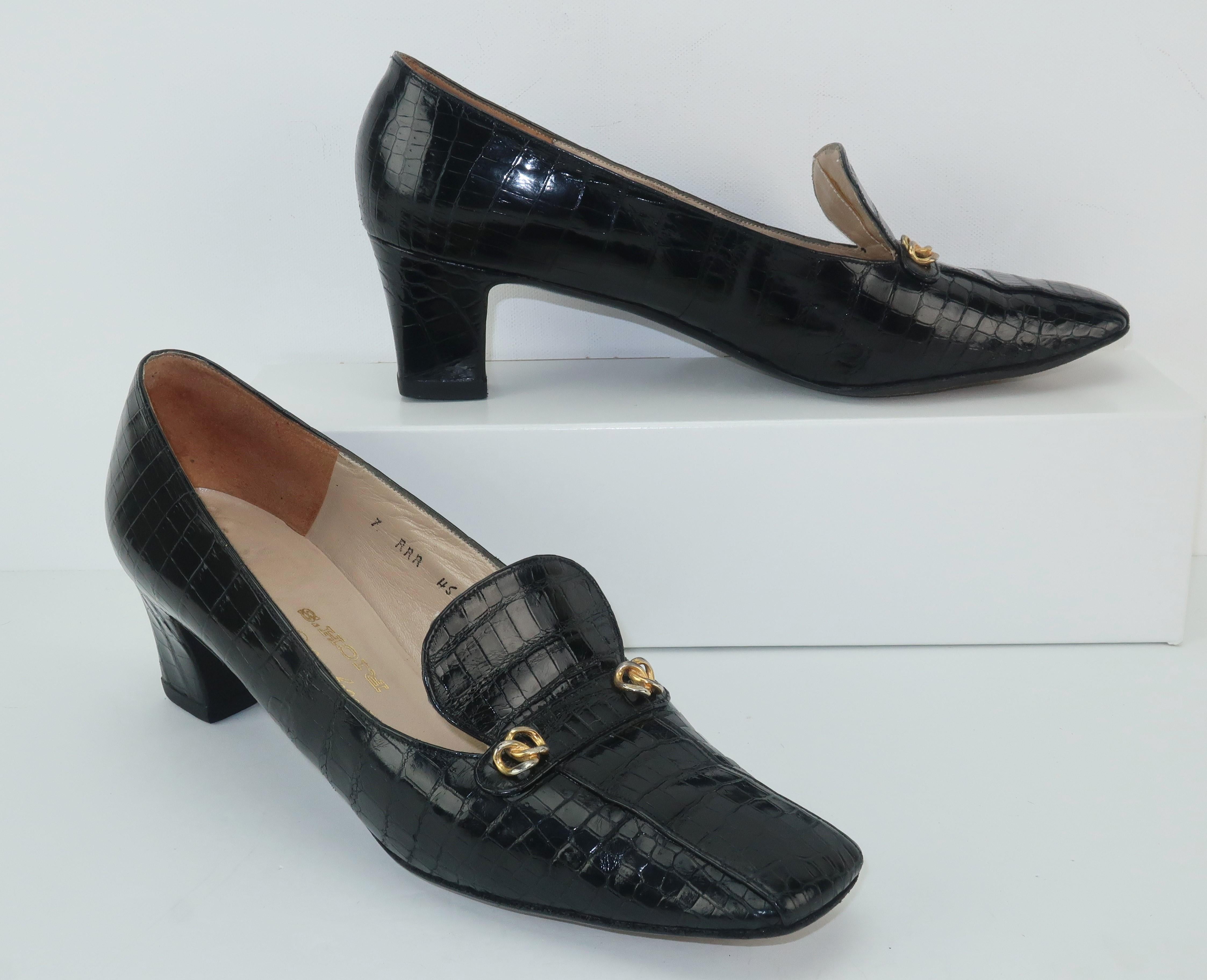 Stylish sensibility!  These Charles Jourdan C.1960 black crocodile shoes are a classic heeled loafer with stylish details including gold tone metal embellishments and a stylized vamp.  The squared toe provides a casual look perfect for skirts and