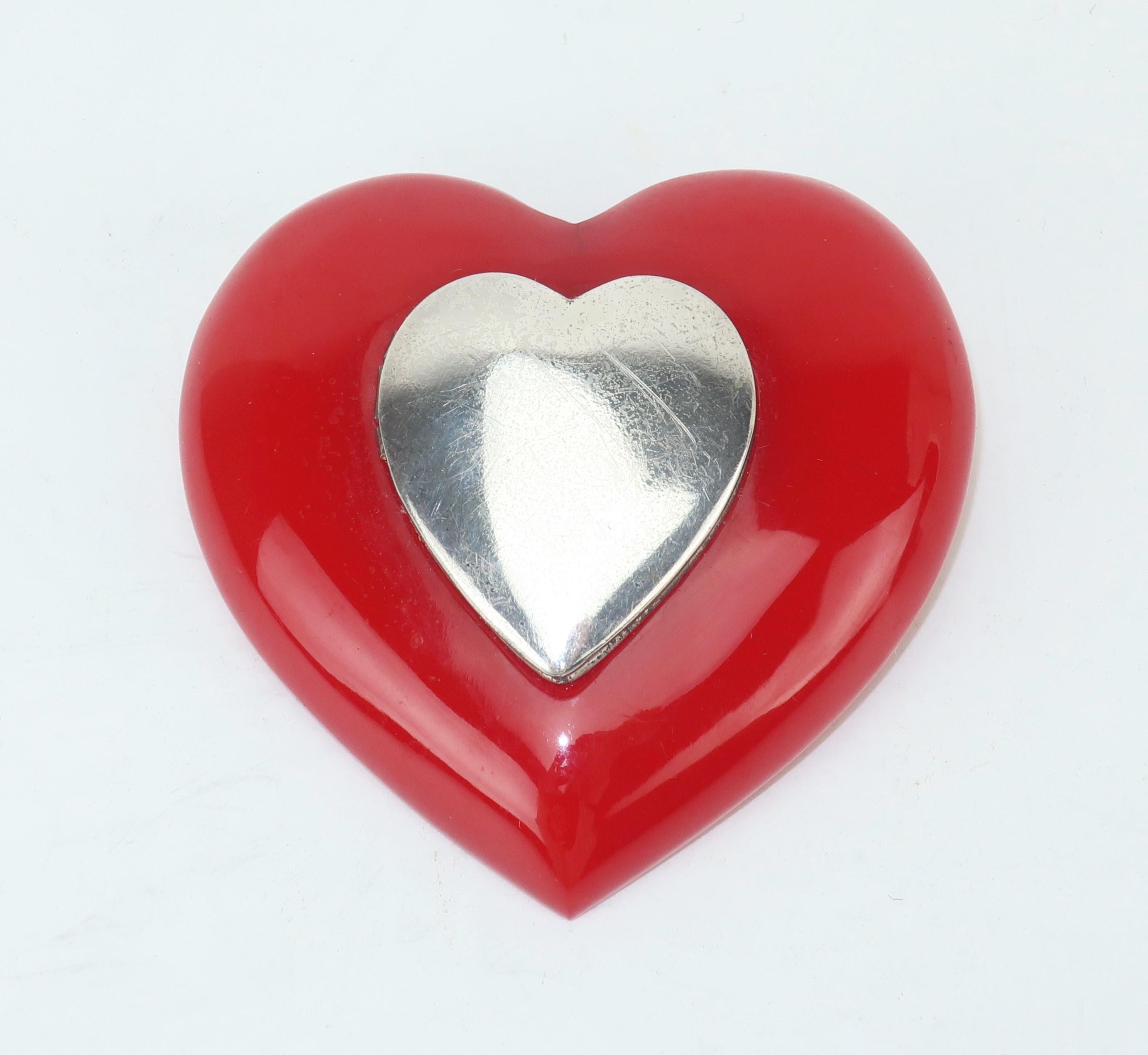 This World War II era Coro red bakelite brooch has the charmingly romantic feature of a sterling silver locket perfect for photos of a sweetheart ... or two!  It secures by a straight pin with a safety catch.  Marked sterling and ‘Coro’ on the