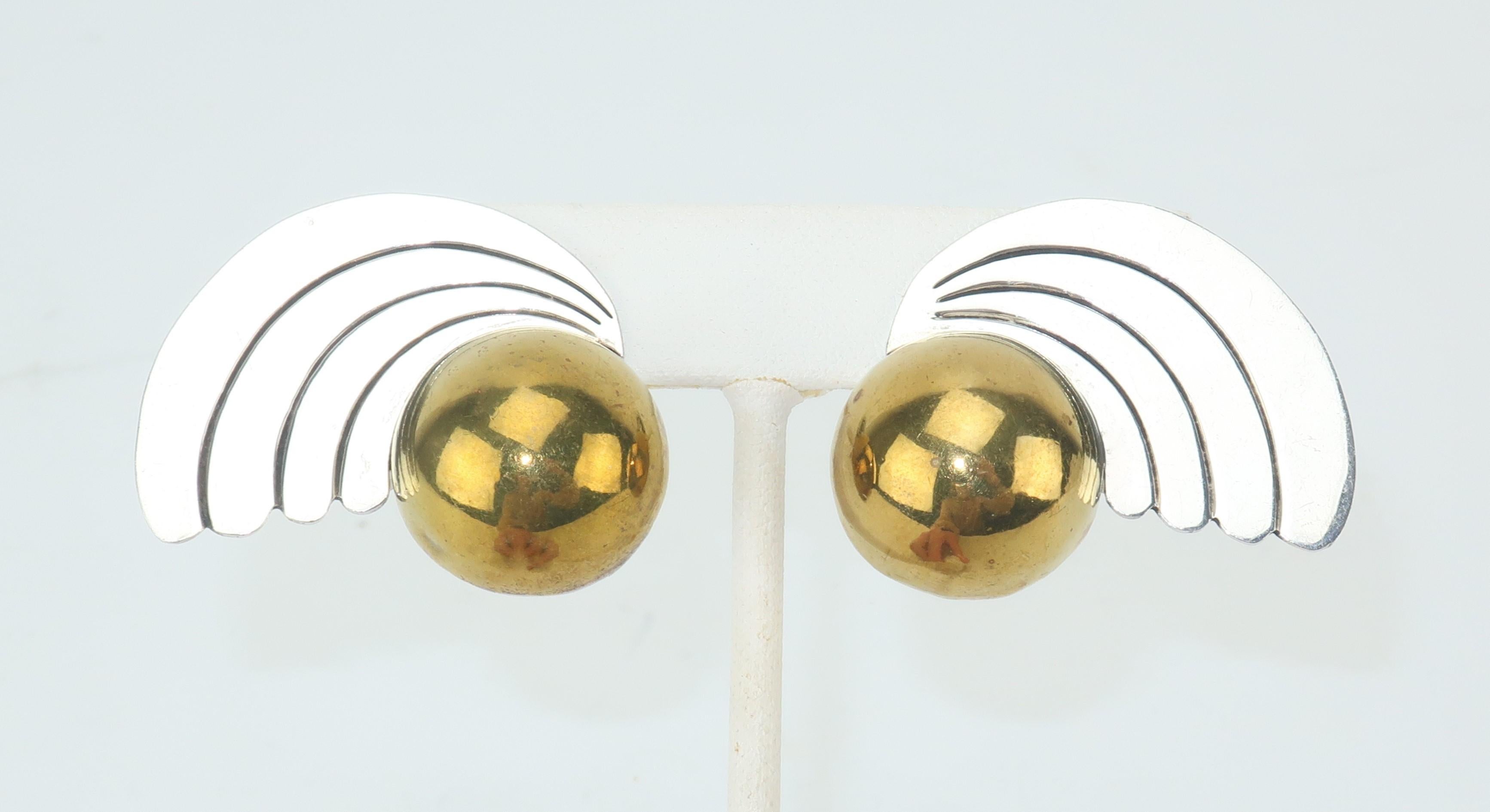 These C.1980 Mexican artisan earrings are inspired by celestial imagery with a silhouette reminiscent of a comet complete with a radiant tail.  The body consists of a brass half orb with sterling silver accents, all backed with clip on hardware. 
