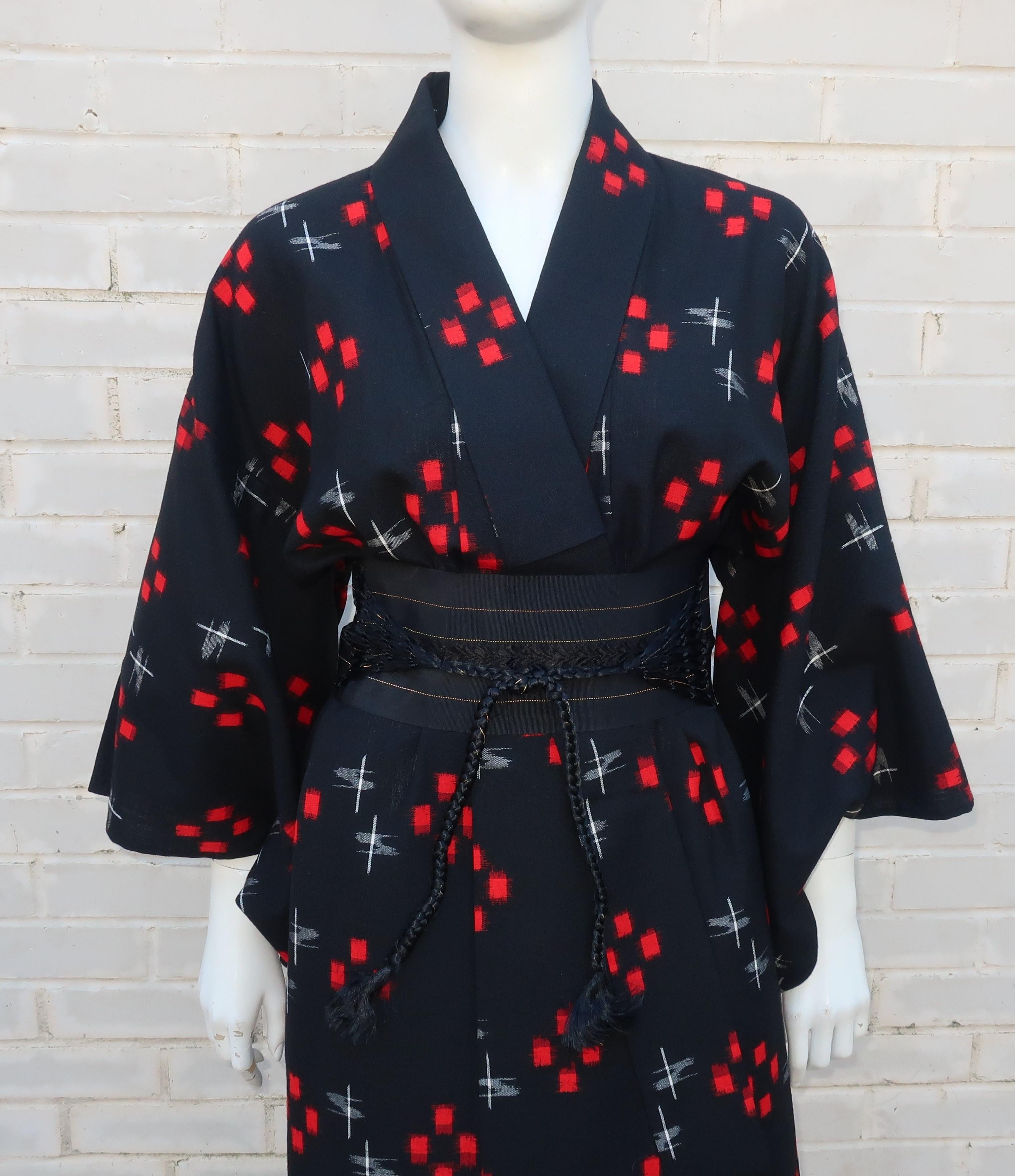 This mid 20th century kimono robe is a fashionable combination of a traditional Japanese silhouette and a modernist red and white starburst pattern on a black background.  The lightweight wool blend is a departure from the ultra feminine silk robes,