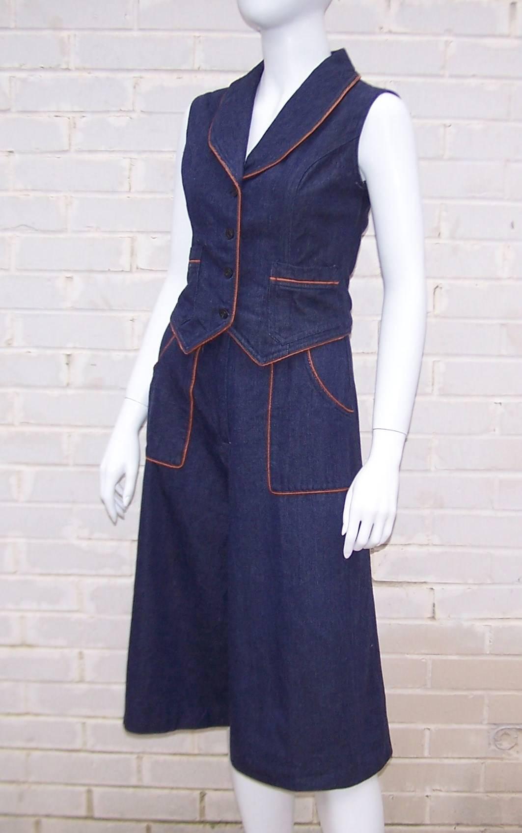 Satisfy a current trend with this fun 1970s denim gaucho pants suit with coordinating vest.  Both pieces are a dark wash denim with contrast faux leather piping.  The gaucho pants have a high waist with large front pockets and the vest has front