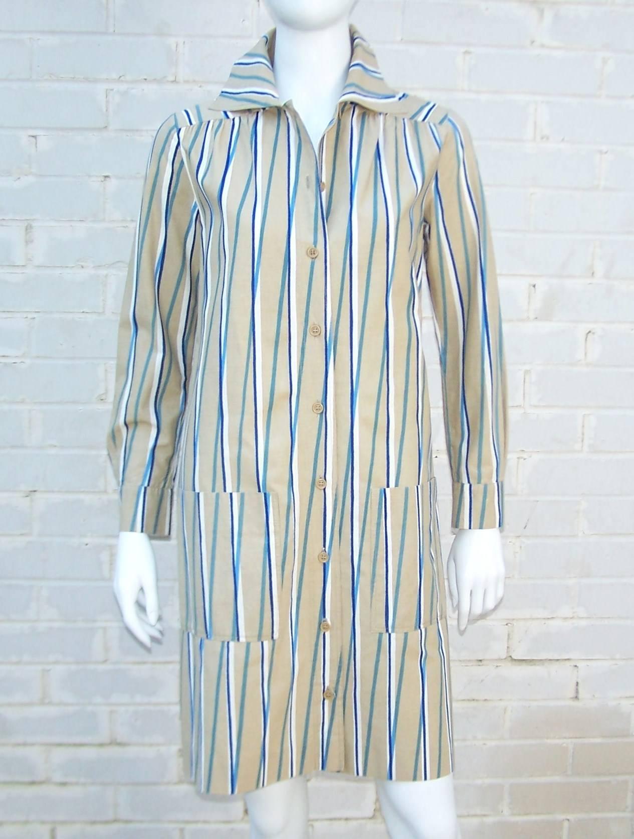 Crisp cotton fabric and a bold op art design are the hallmarks of this 1974 Marimekko shirt dress.  It buttons up the front with large front pocket and bears a resemblance to an artist's smock.  Consider wearing it as a tunic or jacket over