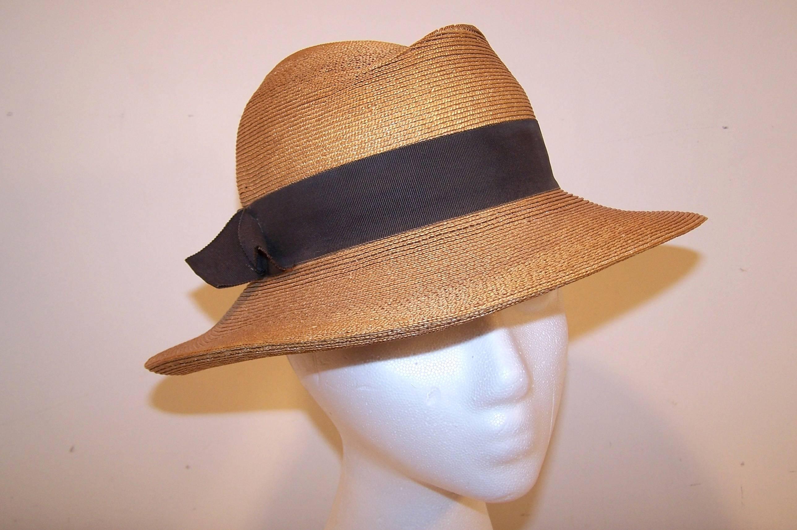 This natural straw fedora hat by Frank Olive is a classic.   The style conjures up images of 1940's menswear summer suits...crisp, detailed and stylized.  It is decorated with a dark brown grosgrain ribbon band on the outside and fleshtone pink band