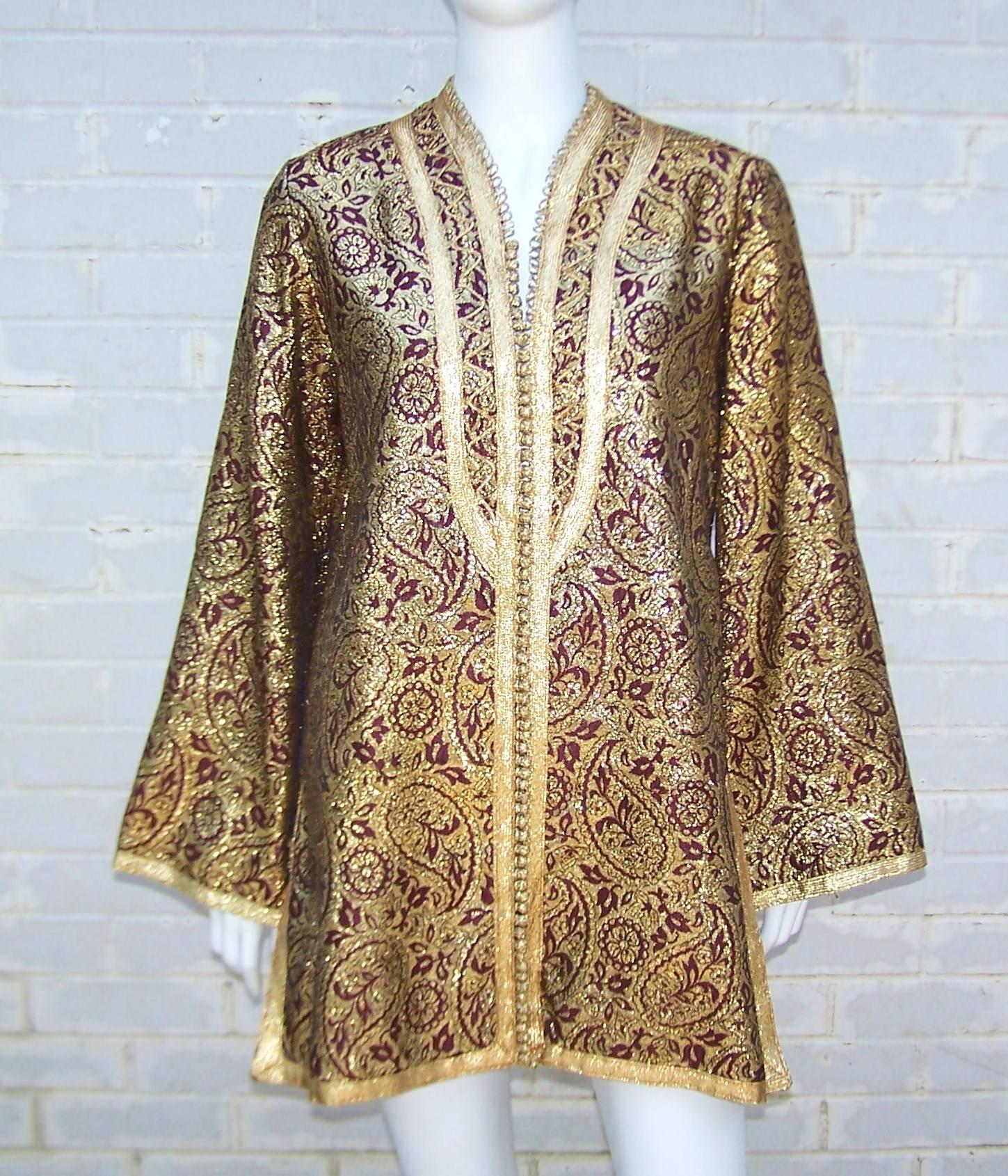 Greek designer, Dimitri Kritsas, brought this classic Moroccan tunic to the halls of New York fashion in the 1960s.  The tunic is made from exotically rich gold brocade with a burgundy red background and lining.  The mile long row of gold buttons
