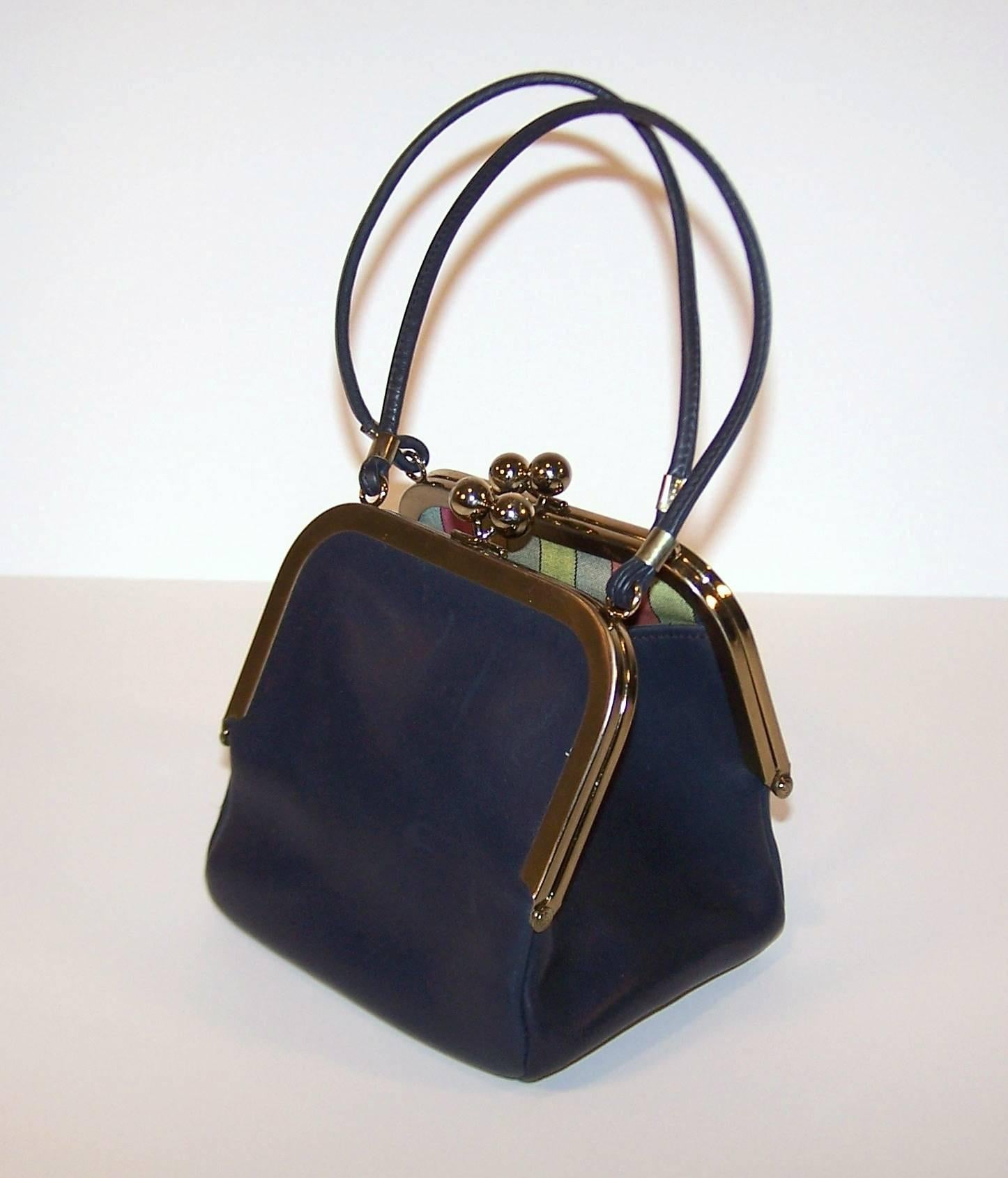 Bonnie Cashin was one of the most innovative designers of her time and her influence continues to be seen in fashionable American sportswear.  This adorable navy blue leather handbag was designed for Coach in the 1960s.  It features two kiss lock