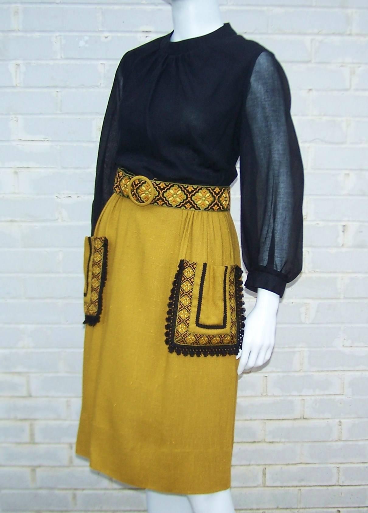 Great day dress for any occasion!  This bohemian style Herman Marcus dress has a black lined muslin bodice with sheer sleeves and a nubby dark gold (with a hint of green) linen blend skirt accented with large front pockets.  The embroidered brocade
