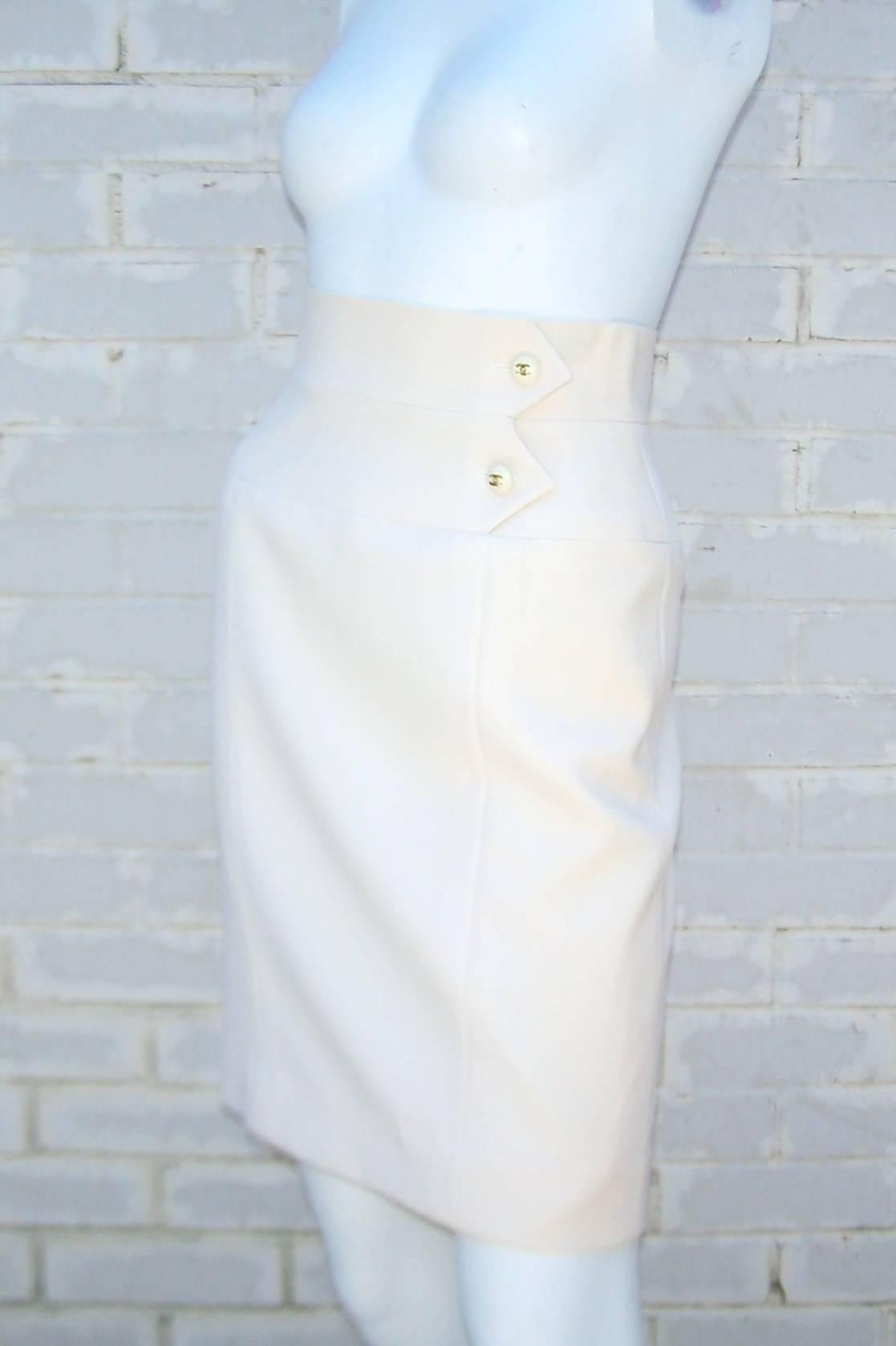 This classic Chanel winter white skirt knows no seasons and can be worn to achieve many looks all year long.  The skirt zips and hooks at the back with inside hooking waistband.  There are two arrow details at the waistline with 'CC' logo buttons