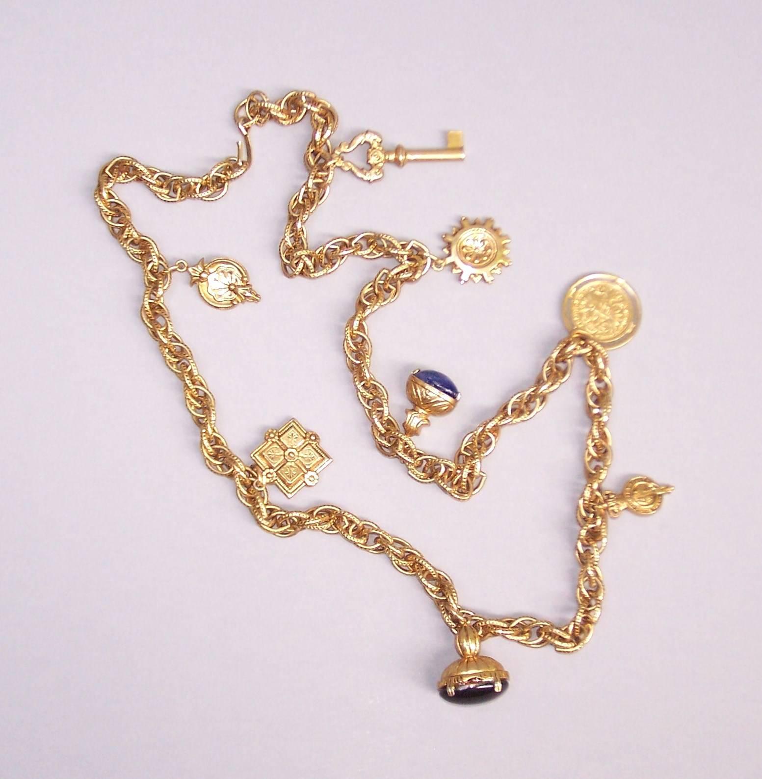 This 1980's gold tone rope necklace is decorated with old world Victorian style charms to create a stylish accessory for any ensemble.  It measures 36" long with eight charms and securely closes with a simple hook.  Wear it long or double it up