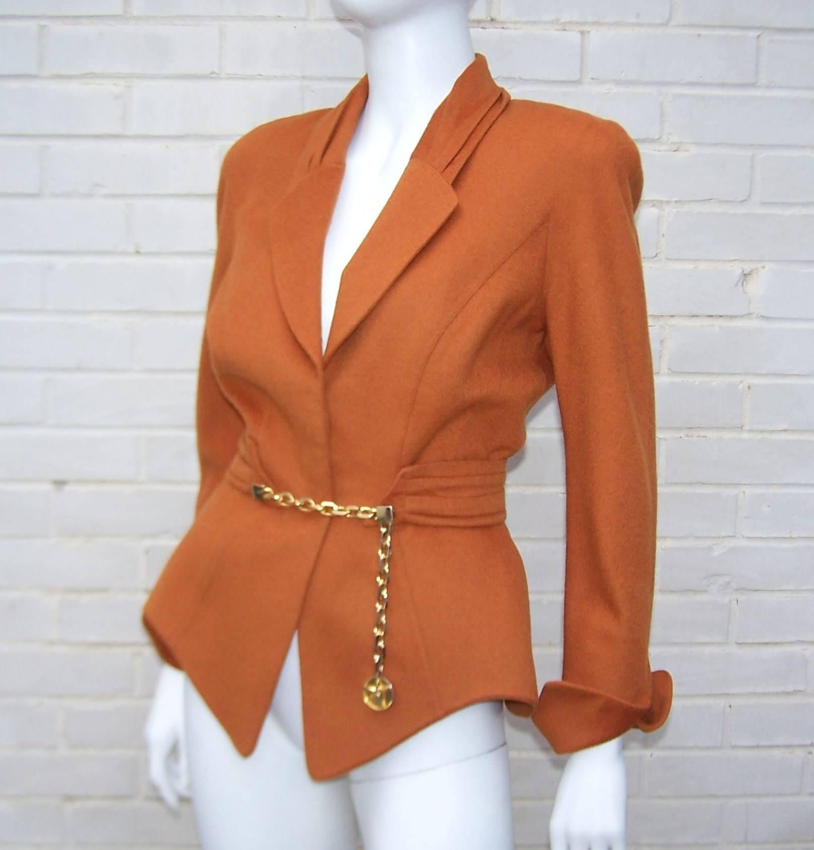 Attention to vintage style details with a unique futuristic silhouette are all hallmarks of French designer, Thierry Mugler.  This gorgeous wasp waist wool jacket is a beautiful pumpkin brown with soft pleating at the collar and a cummerbund style