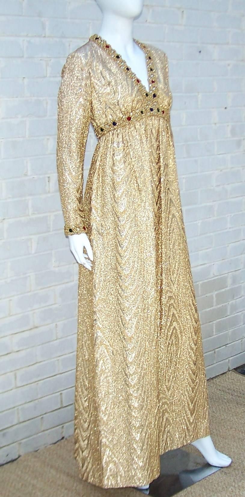 This Anne Fogarty empire maxi dress has the midas touch.  The heavy gold lame fabric has a moire design with textural gold braided trim on the empire waist bodice and cuffs.  The trim is embellished with colorful velvet poms and faceted rhinestones.