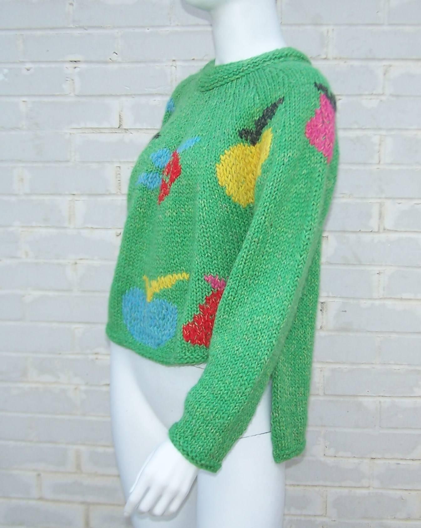 What a cutie!  Italian designer, Enrico Coveri, paired bright green wool with colorful fruit images to make a cozy bear hug of a sweater.  Even better, he created an playful silhouette by cropping the front and providing a long tail in the back. 