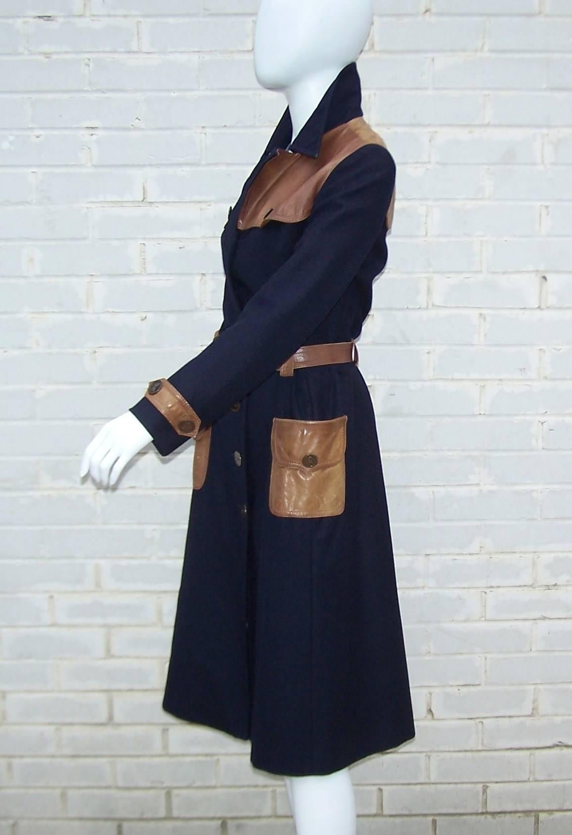 This is a trench coat worthy of a Bond girl!  Medium weight navy blue wool is expertly styled with tan leather details and bronzed buttons decorated with Roberta Di Camerino’s signature trompe l’oeil buckle logo.  It is fully lined and buttons at