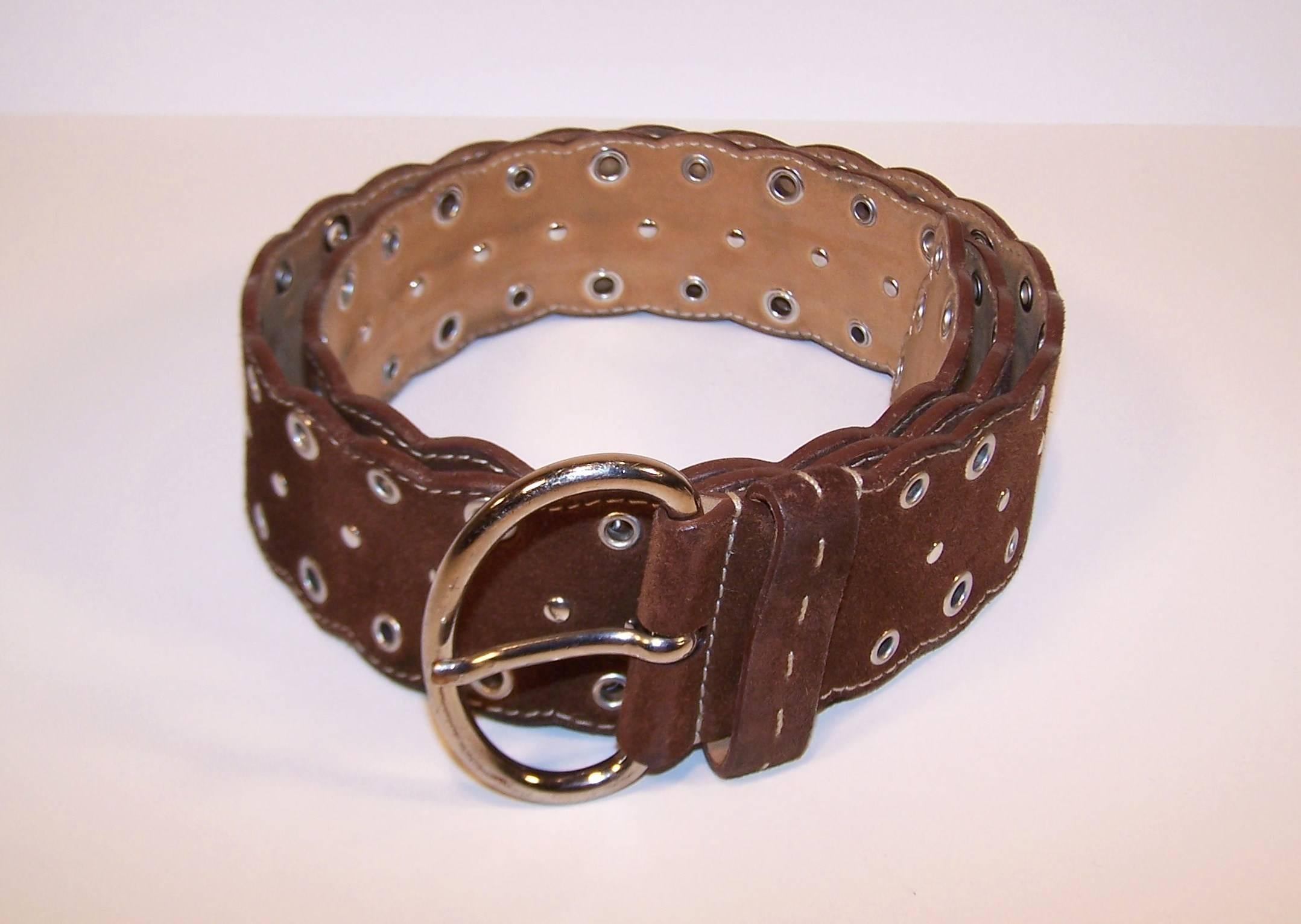 Prada has stepped back to the 1960's with this bohemian inspired chocolate brown suede belt.  The belt has a scalloped pattern decorated with silver tone grommets, studs and buckle to complete the look.  Fabulous worn with jeans...hiphuggers, even