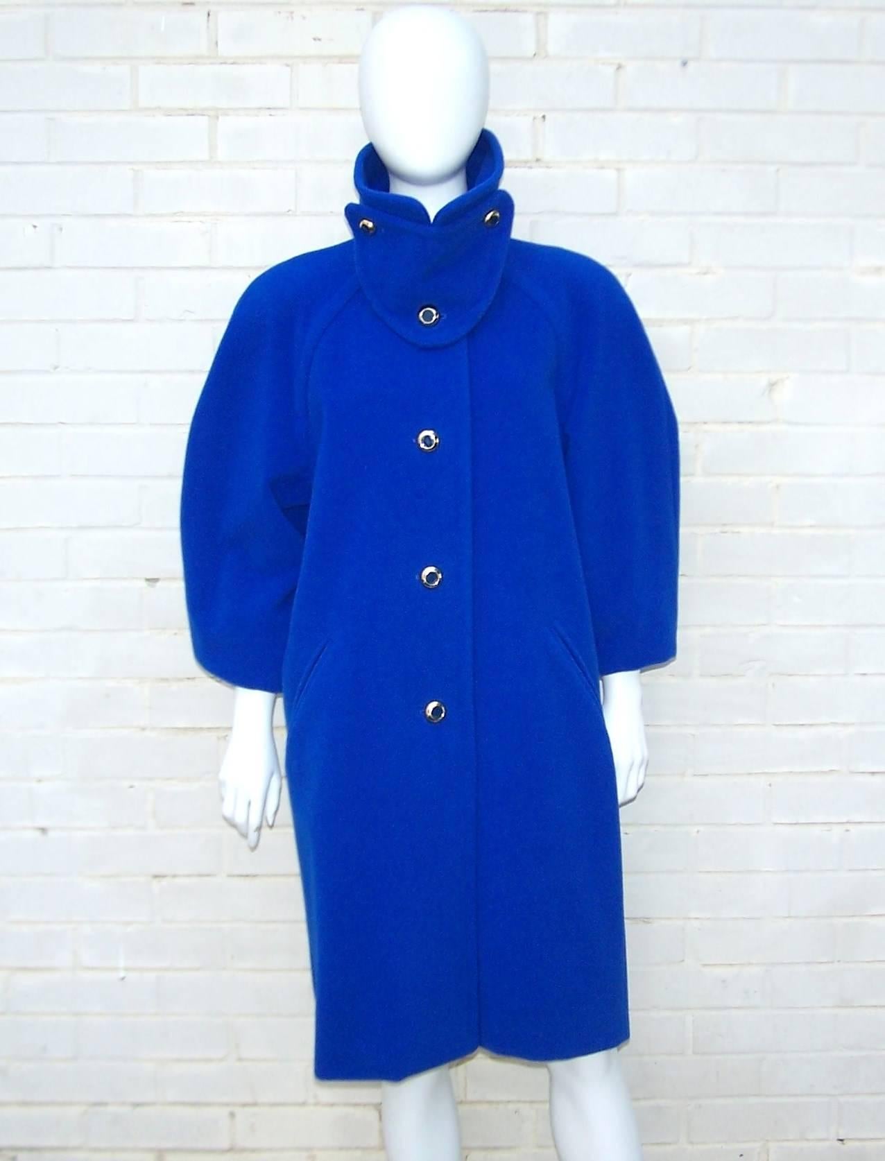 You'll be longing for a cold day so you can don this bear hug of an Escada coat!  The cozy style is enhanced by virgin wool that is soft as cashmere and the electric blue color will bring light to a gray day.  The unique triangular bib closure