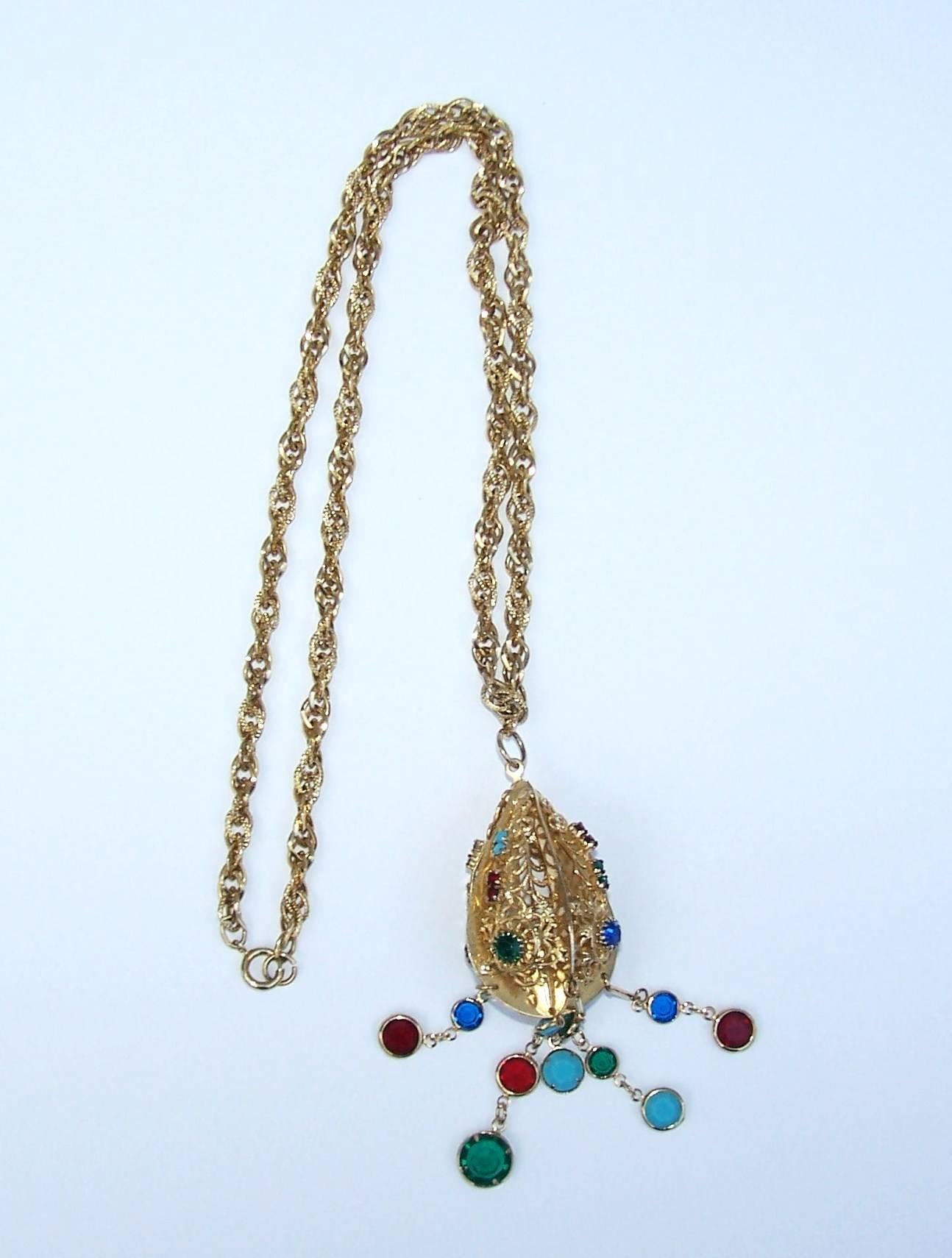 This fashionably fun necklace is an ovoid shape pendant embellished with both rhinestones and suspended articulated dangles that dance with movement.  The pendant hangs from a high quality gold tone metal rope chain with a springring closure.  Pair