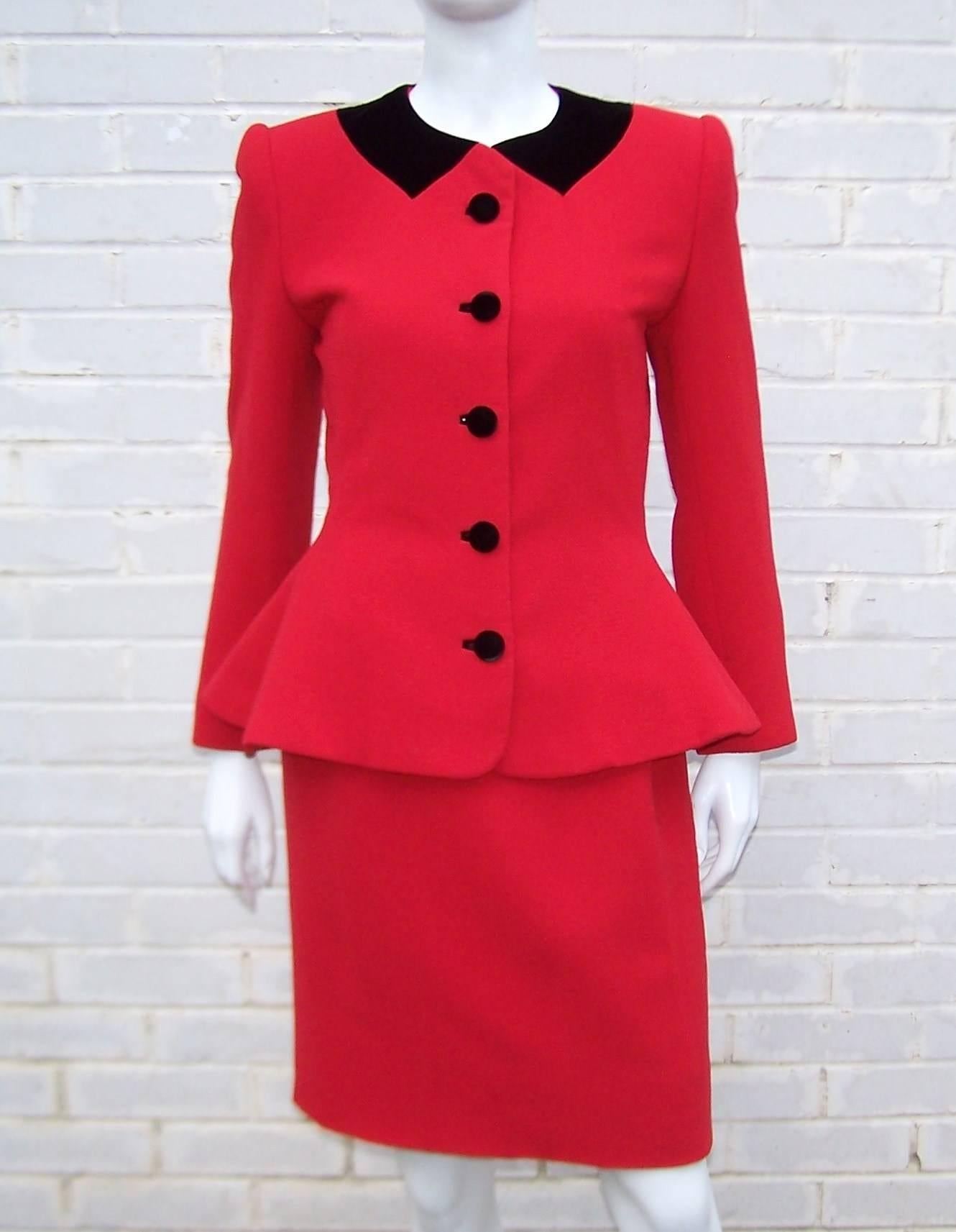 This sweet suit has an ultra feminine shape and details to please.  The vibrant red wool crepe is accented with a trompe l'oeil black velvet collar and large buttons.  Strong shoulders and a narrow torso yield to a peplum flounce that is flattering