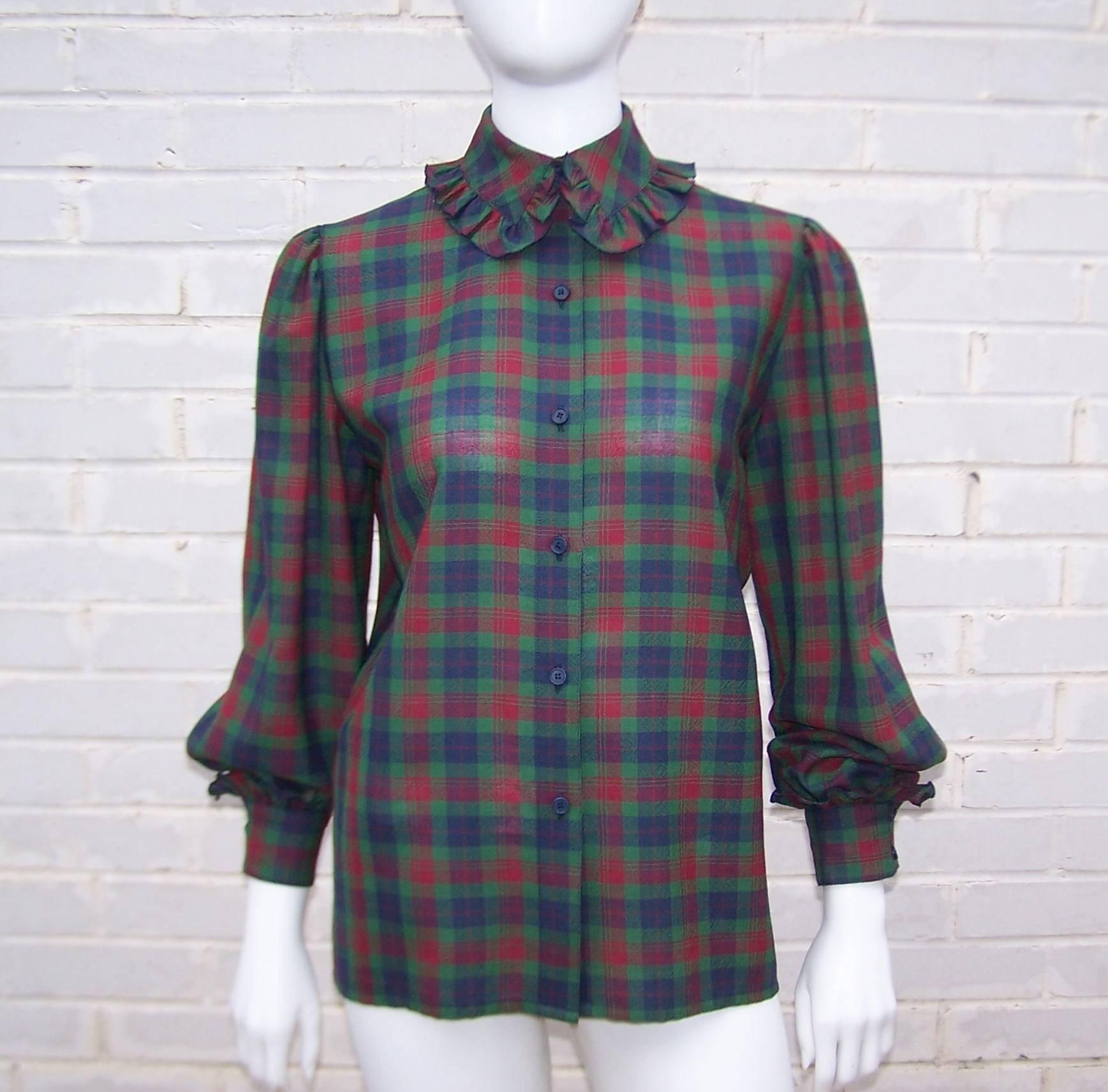 This is a charming 1970's wool plaid shirt with a style reminiscent of a turn-of-the-century school girl.  It buttons at the front with a rounded ruffled collar and a boxy construction.  There is soft pleating at the shoulder and wide ruffled cuffs