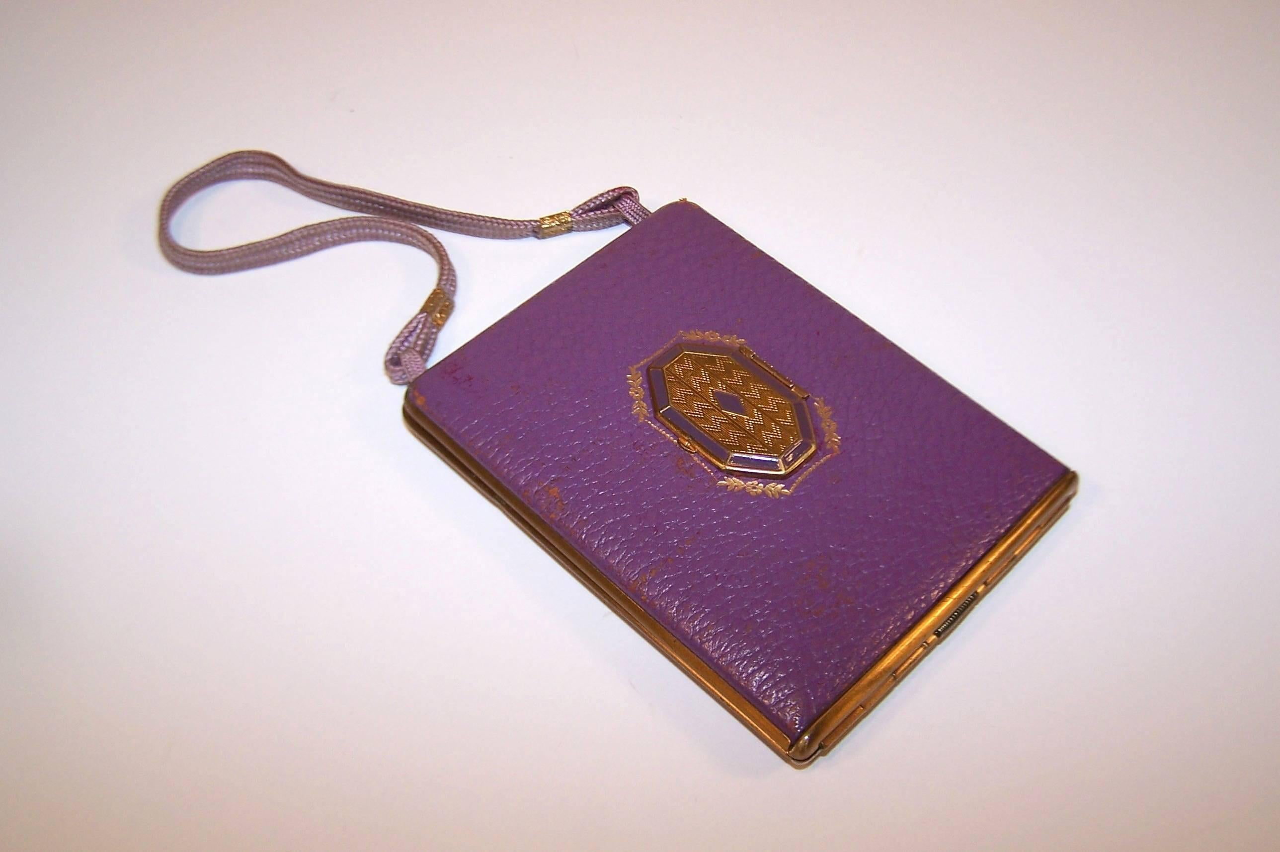 Much like chantelaines, elaborate mirrored compacts are feminine gadgets of a bygone era ... and oh so fun to explore!  This unique example from Mondaine of New York is a vibrant purple leather with guilloche decoration on the exterior and interior.