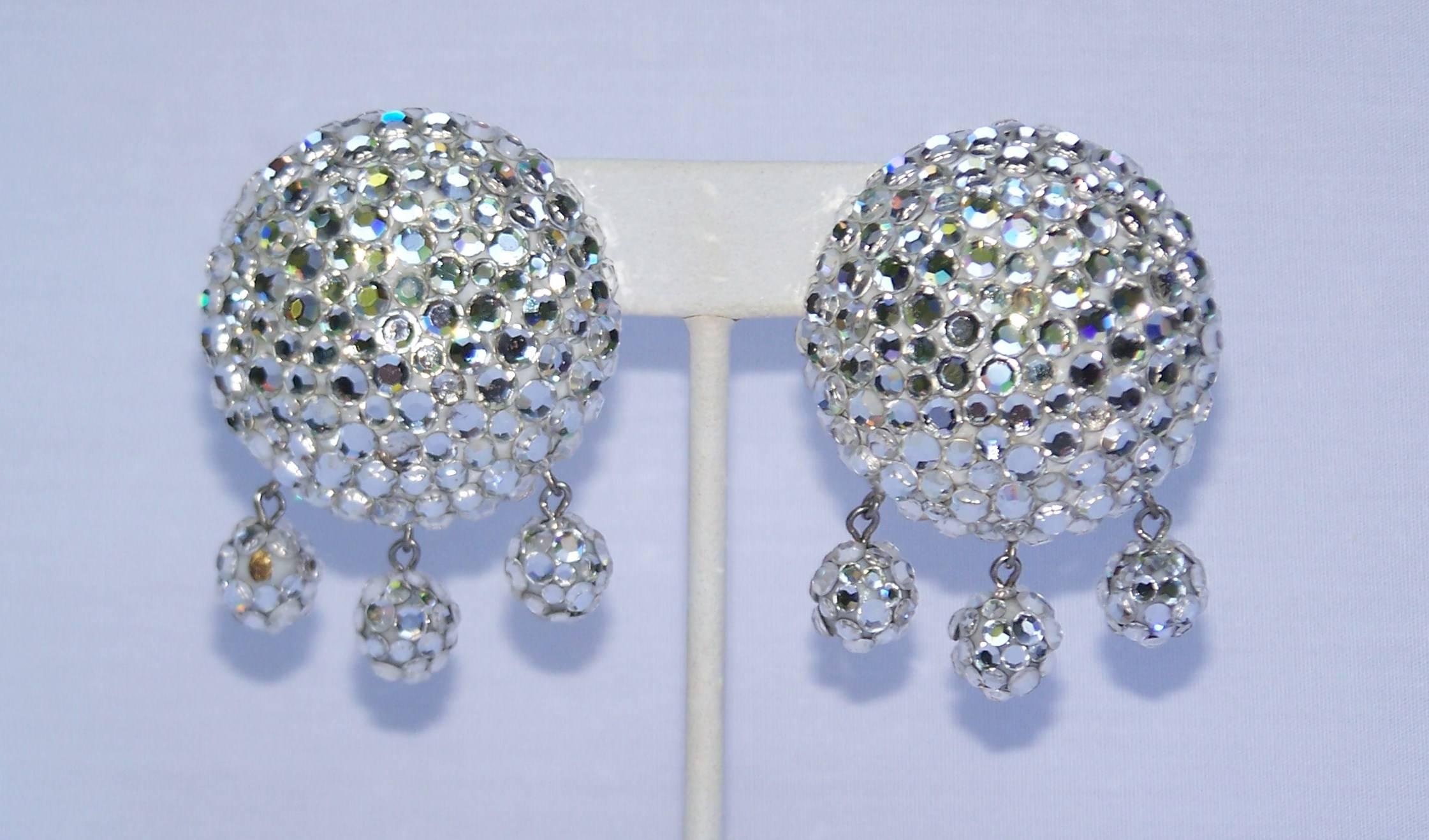 Glitzy, glittery, glammy ... all appropriate adjectives to describe these fun pave crystal encrusted earrings by James Arpad.  Each bauble is like a disco ball for the ears with a flat clip on back and three dangling small balls to move and catch