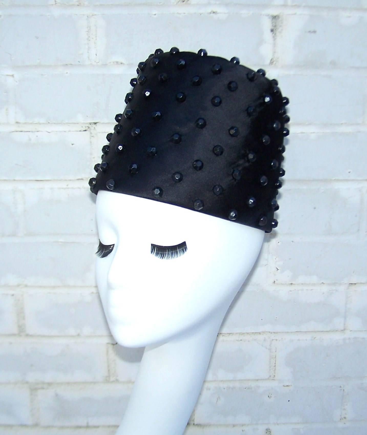 Have an exotic evening in the Casbah in this black satin fez style hat with faceted black beads.  Easy to wear shape that can also be styled cocked to one side for more of a 1940's look.  Pair it with an evening coat or complete the exotic look with