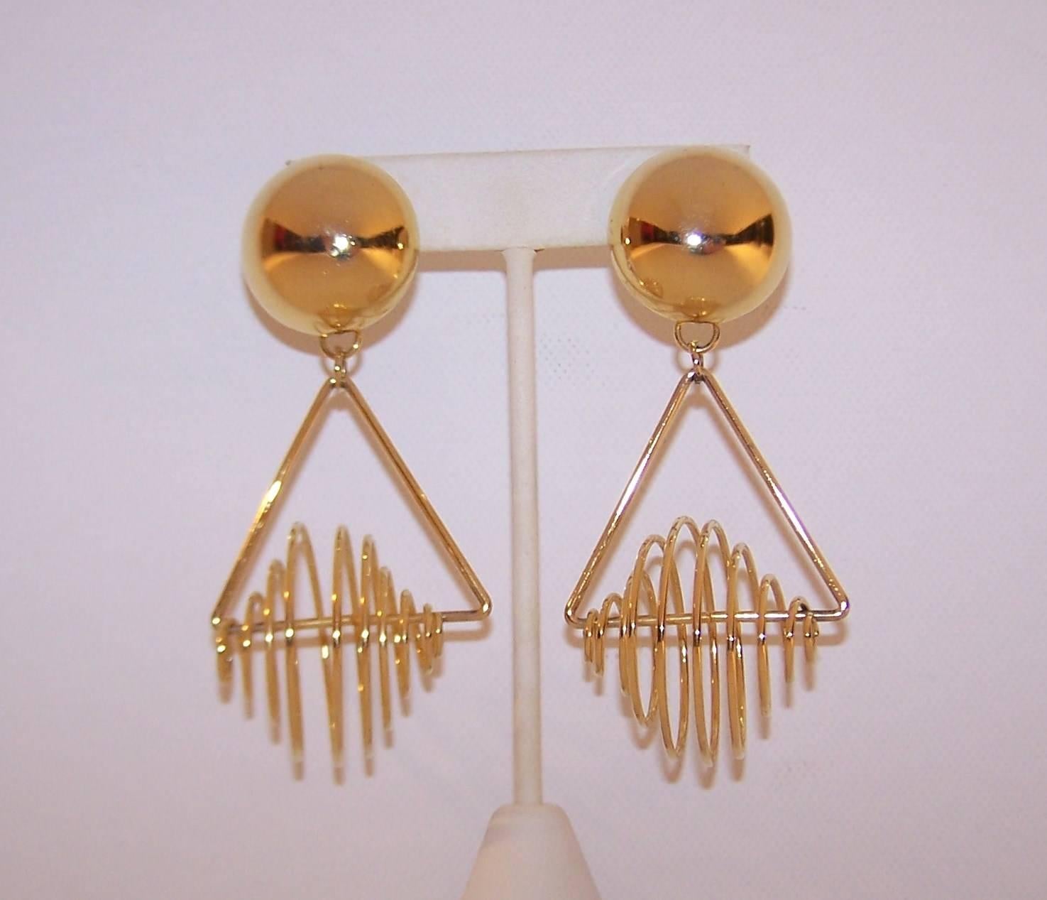It's an op art mobile for your ears!  These fun gold tone earrings consist of a circular domed disc with a dangling triangle outfitted with a loopy spiral.  They are light weight and comfortable for all day wear.  Unsigned but fabulous nonetheless. 