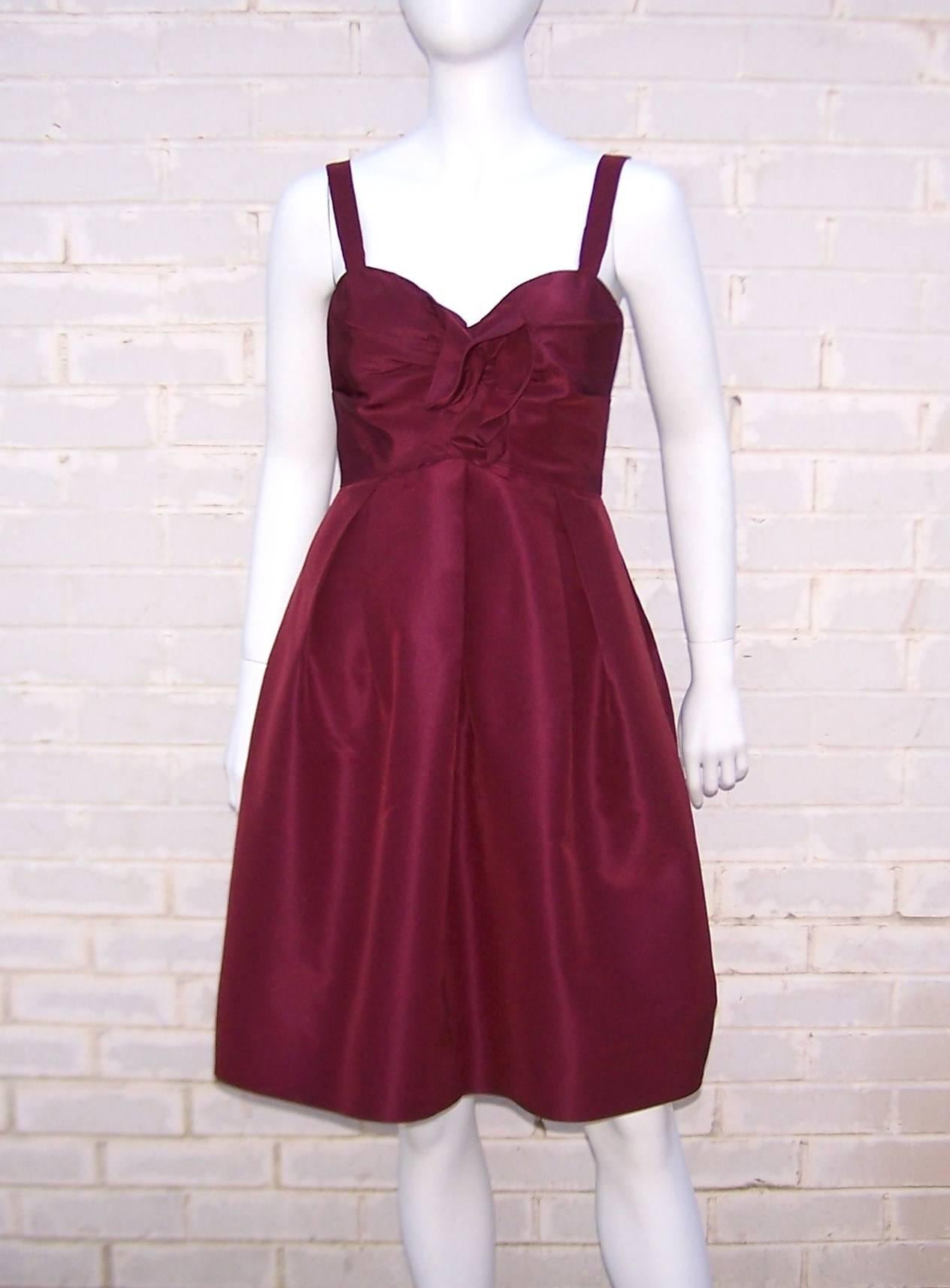Oh the luxury and opulence of an Oscar de la Renta dress!  This beautifully designed gown has an elegant old school look with a good dose of modern sculptural construction.  Starting with rich aubergine silk taffeta, Mr. de la Renta formulates a