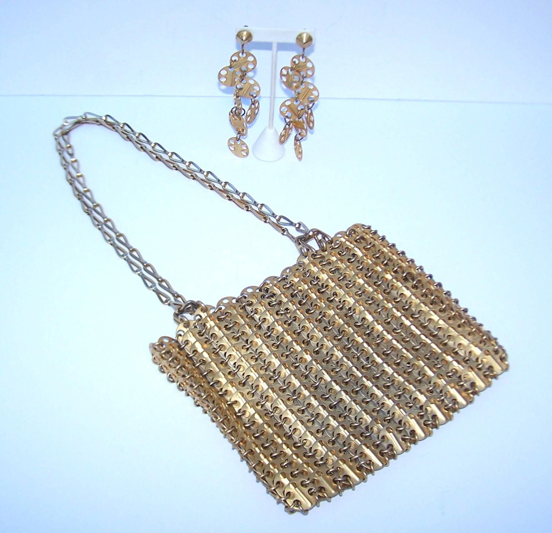 Paco Rabanne's iconic and ground breaking designs from the 1960's are true fashion history.  This handbag with coordinating earrings are excellent examples of his work.  The handbag is expertly constructed with interlocking gold tone aluminum discs