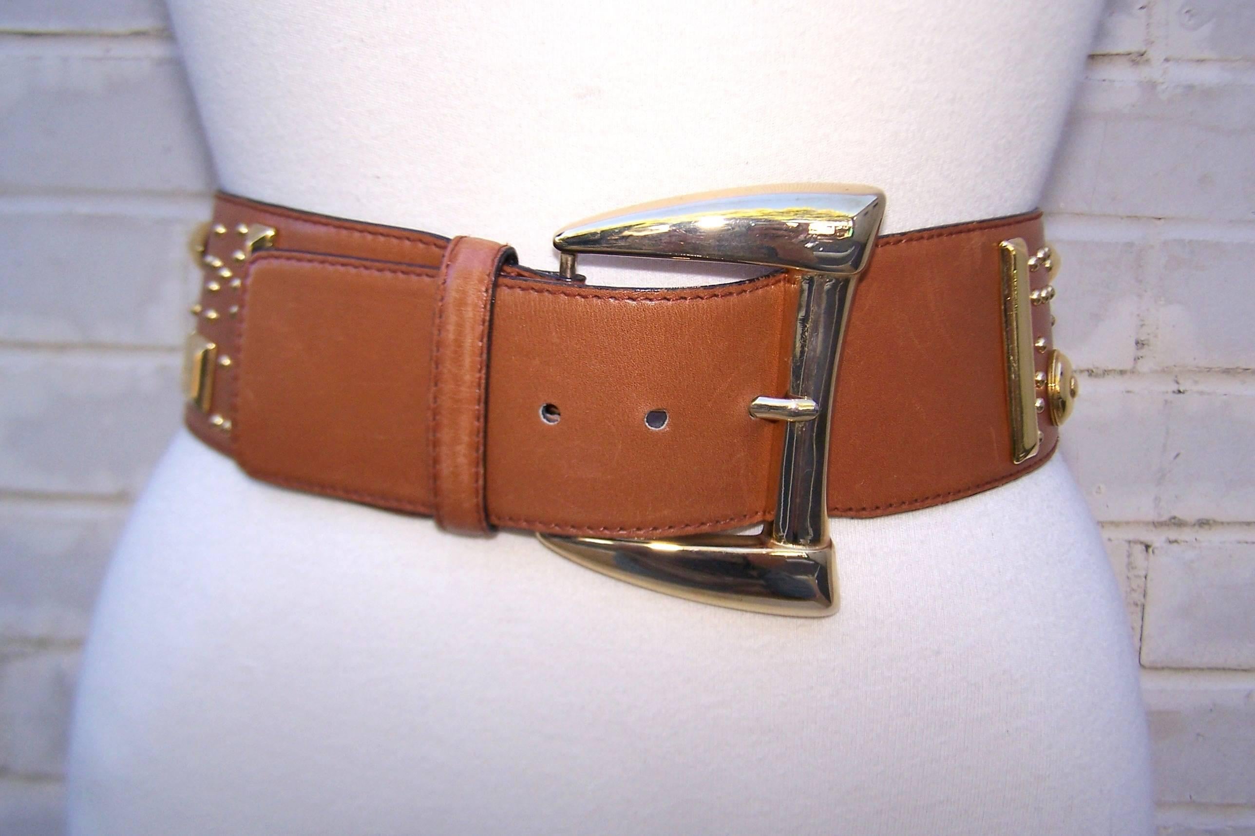 This Escada belt means business!  The neutral camel color leather looks great paired with many other shades and the addition of the gold studs in geometric shapes lends the belt a funky vibe sure to spice up an outfit.  Dresses, trousers or the