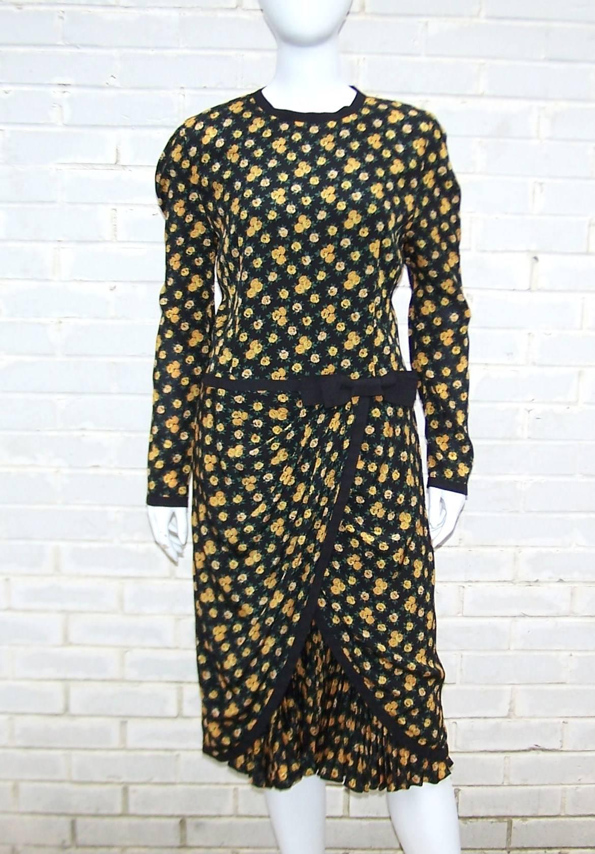 Louis Feraud's ladylike style gives way to girlish details in this dress from the 1980's.  The silk blend dark floral is a black background accented with yellow flowers and a touch of green foliage.  The waist drops to a softly pleated hip line