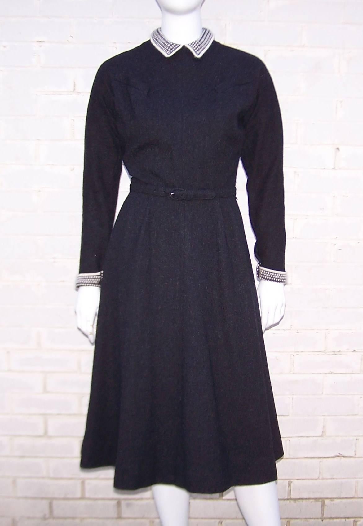 This charcoal gray wool dress conjures up images of fur ear muffs and ice skates.  It zips and hooks at the back with a coordinating skinny belt and faux breast pockets.  The raglan style bodice cinches at the waist and gives way to a full skirt